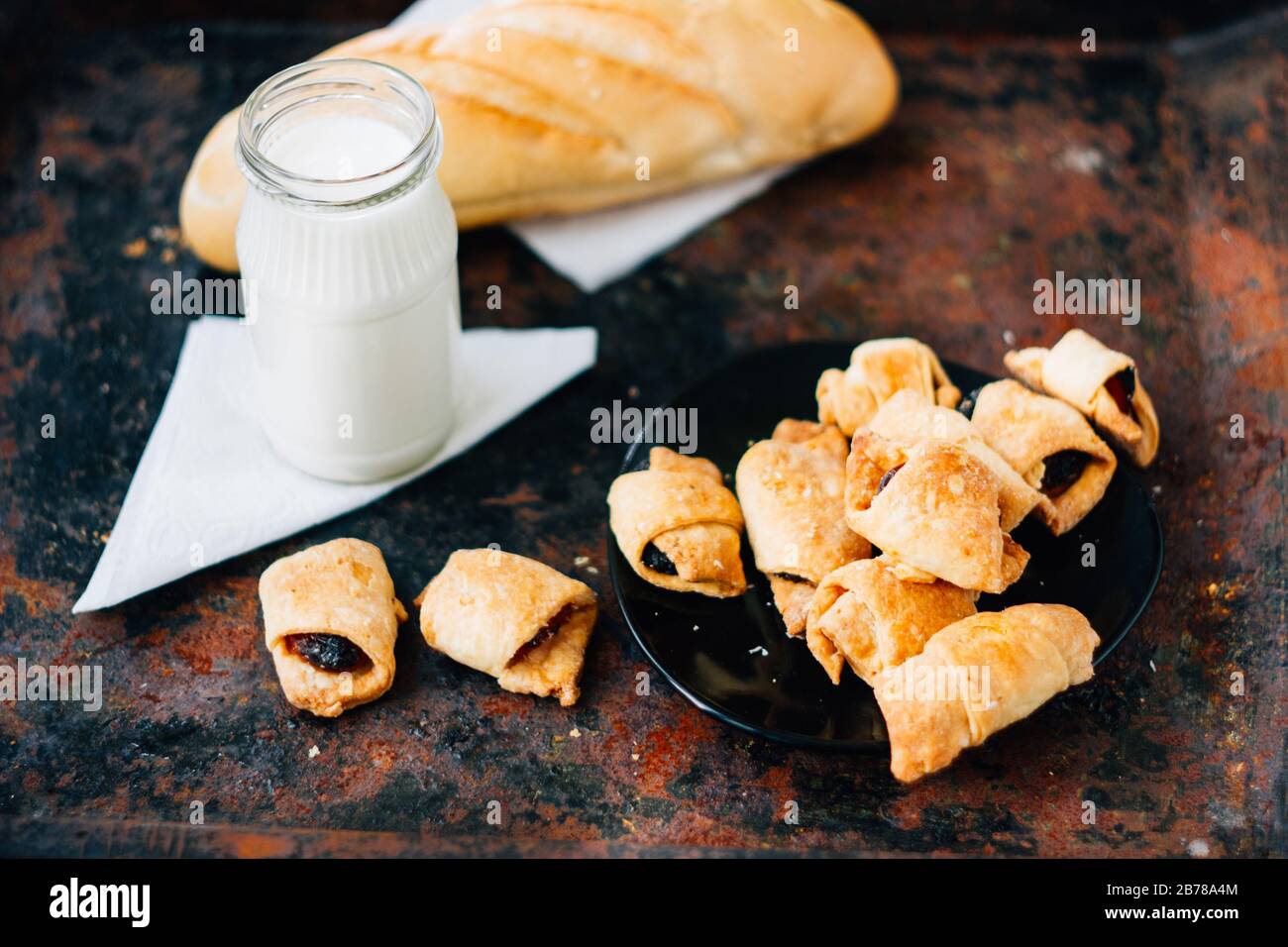 Nice breakfast - milk with croissants on black rustic surface Stock Photo
