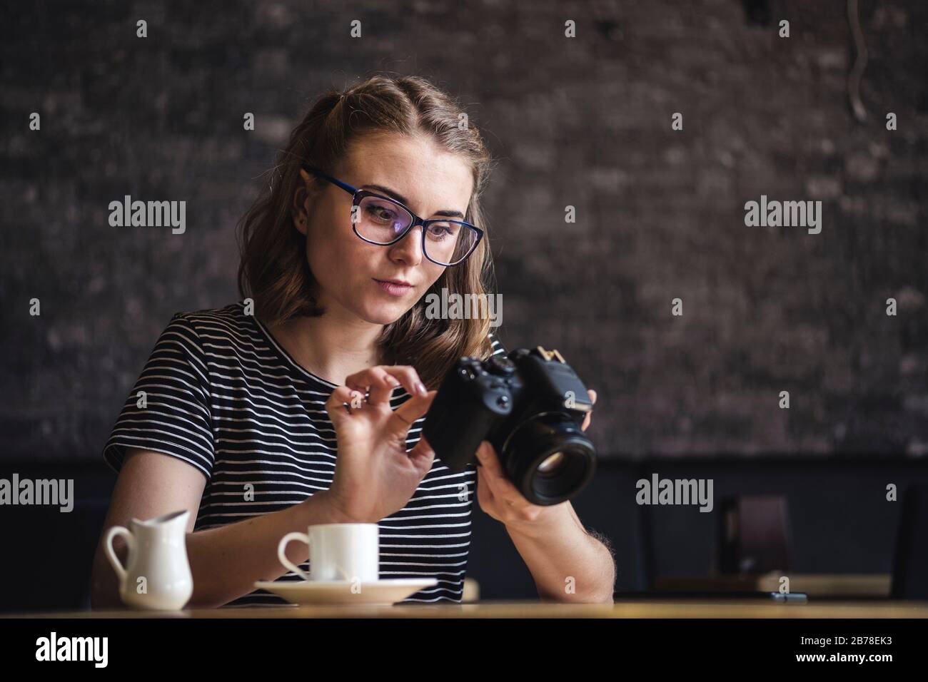 Young woman photographing chimping her photos as she sits relaxing ...