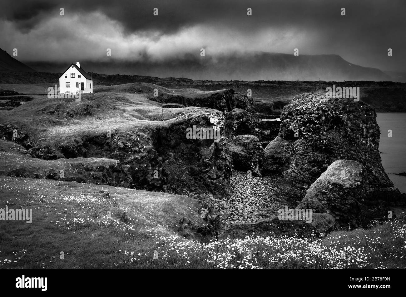 Dramatic Icelandic landscape with steep rocks and a lonely house. Stock Photo