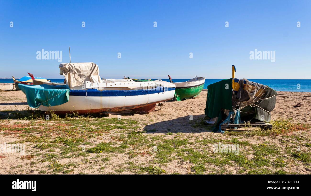 Old fishing boats aground on Badalona beach in the Mediterranean Sea in a sunny day. Barcelona, Catalunya, Spain. Stock Photo