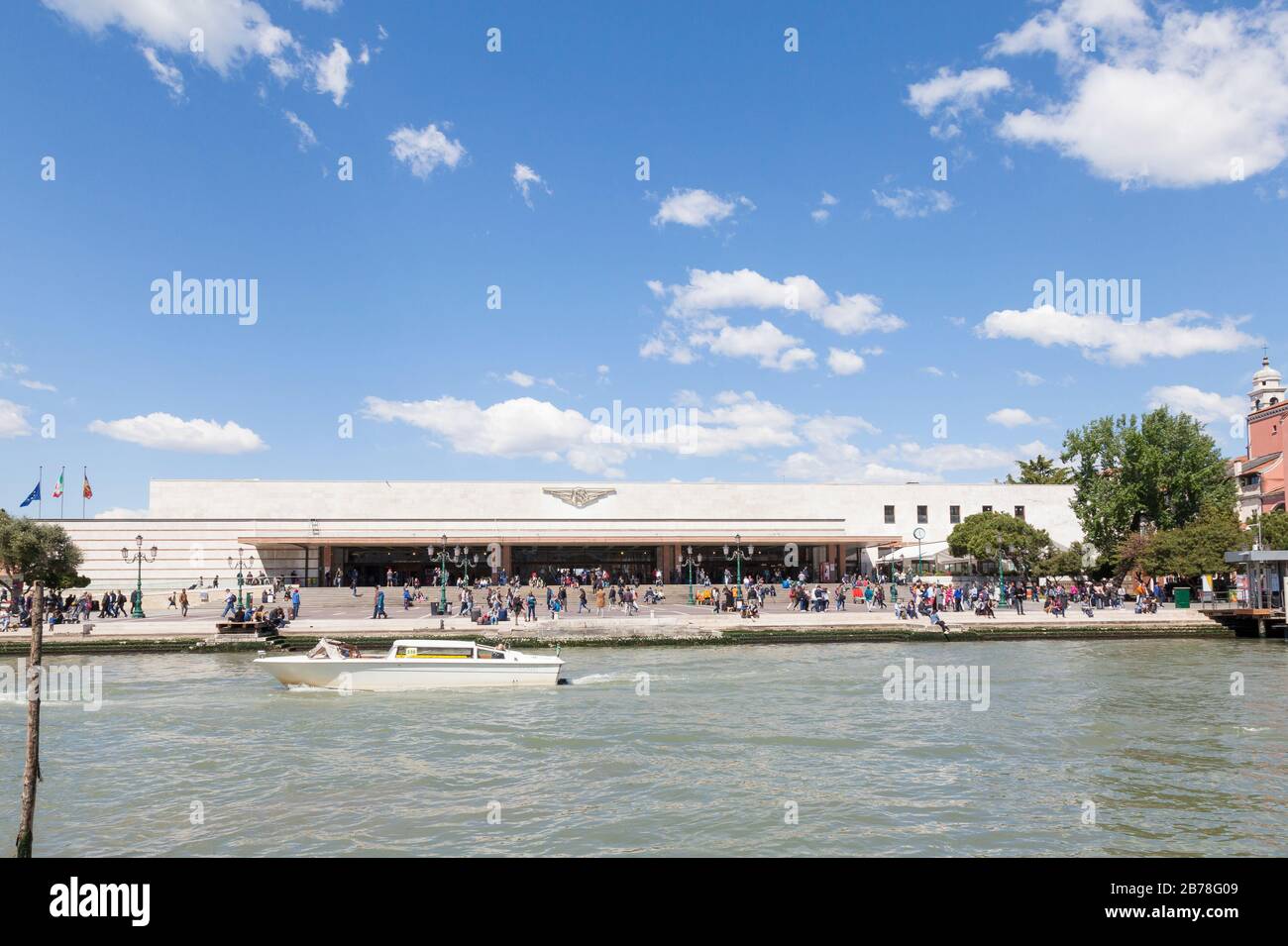 Ferrovia, or Santa Lucia Railway Station,  Grand Canal, Cannaregio, Venice, Veneto, Italy with tourists and a water taxi passing by Stock Photo