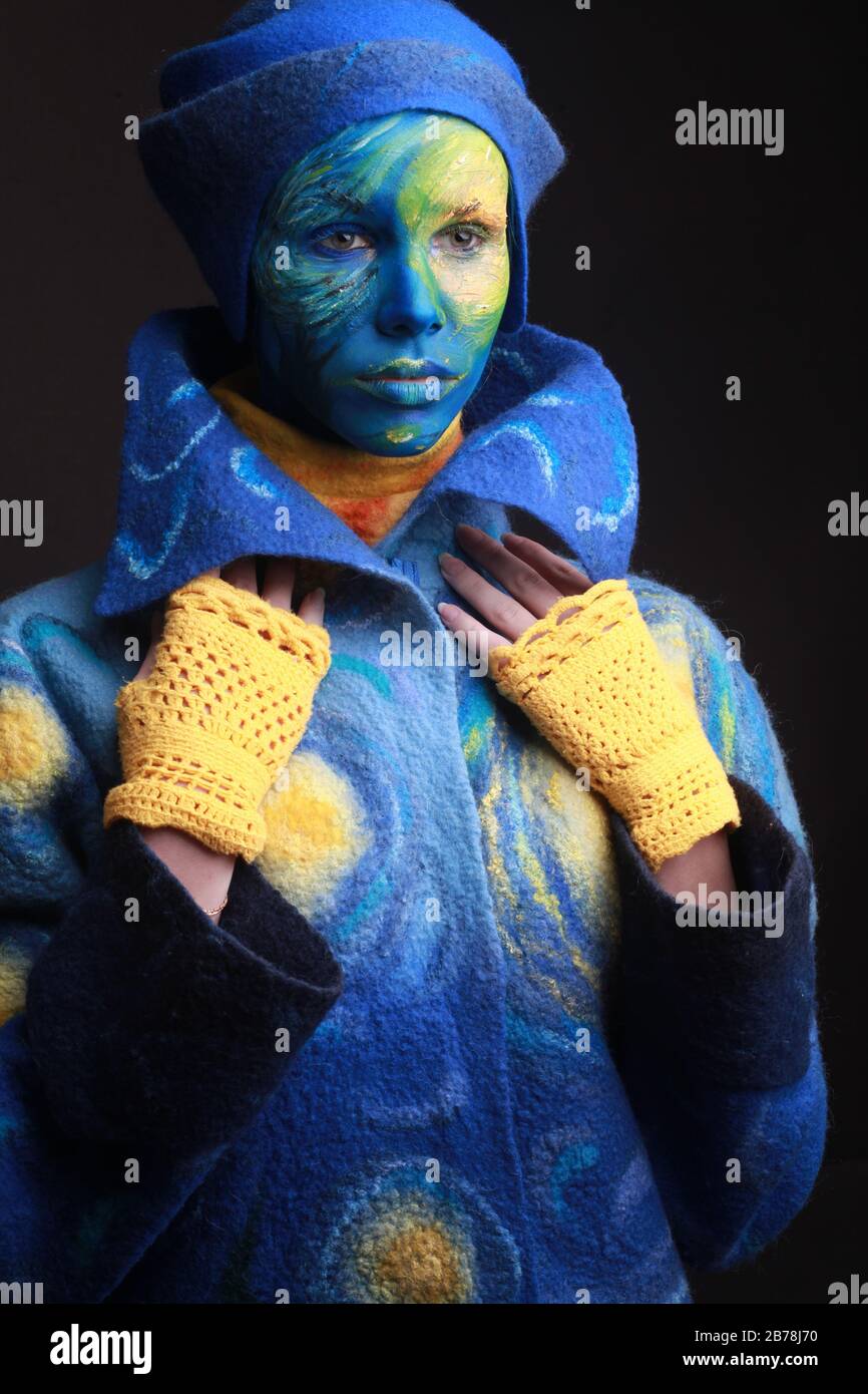 Living painting woman completely covered with thick paint, body art