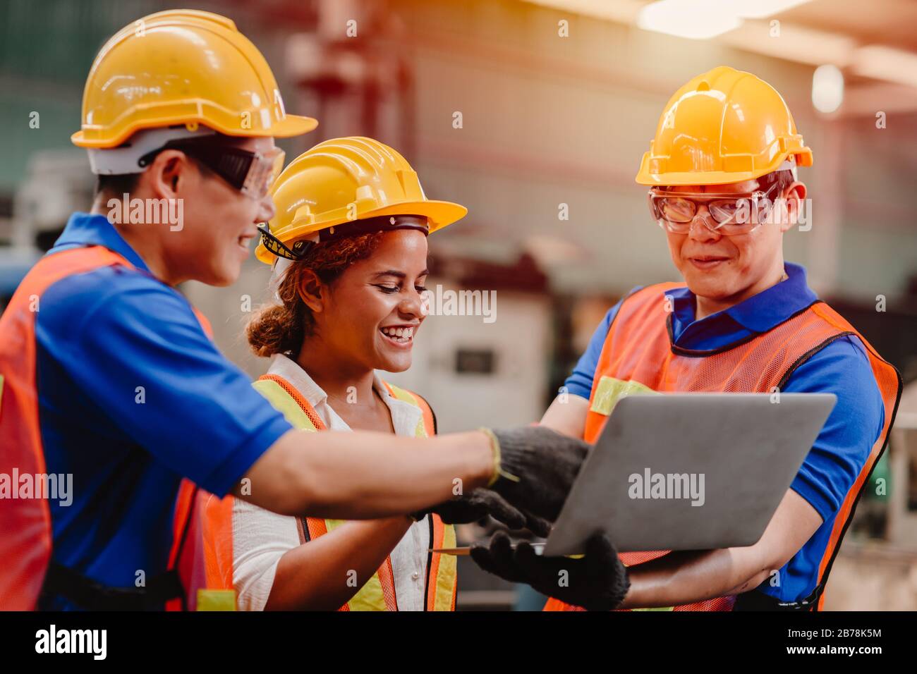 engineer team mix race working together in heavy industry with laptop computer discussion, join engineer teamwork. Stock Photo