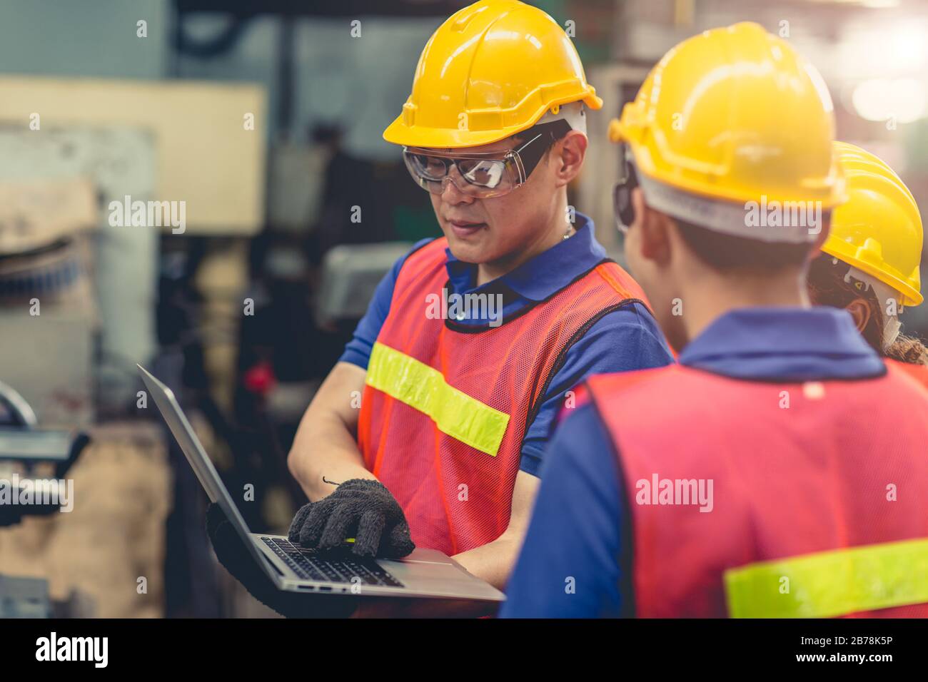 engineer team mix race working together in heavy industry with laptop computer discussion, join engineer teamwork. Stock Photo