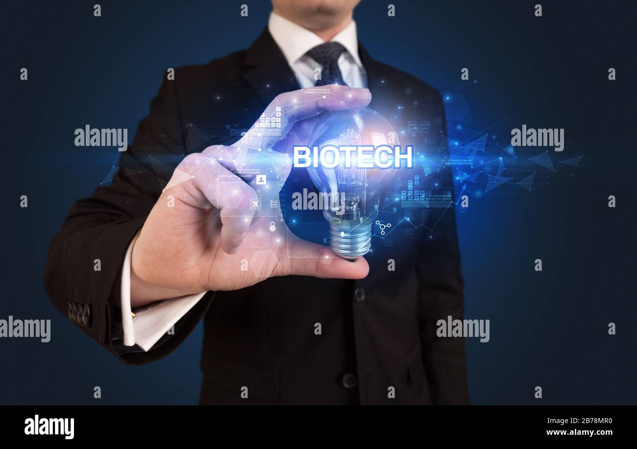 Businessman holding light bulb with BIOTECH inscription, innovative ...