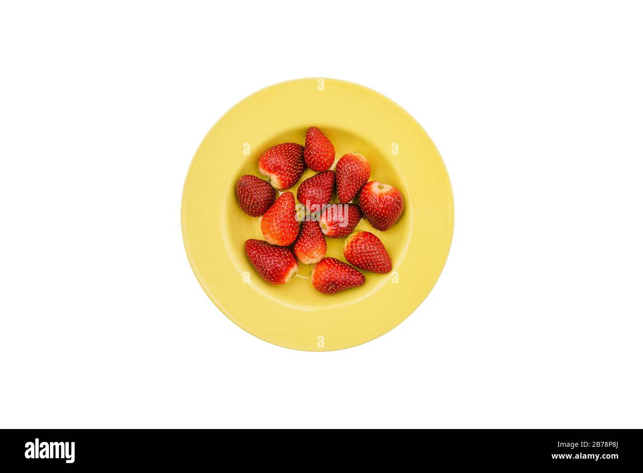 Strawberries in a yellow round plate. Red summer berries isolated on a white background. Flat lay, top view Stock Photo