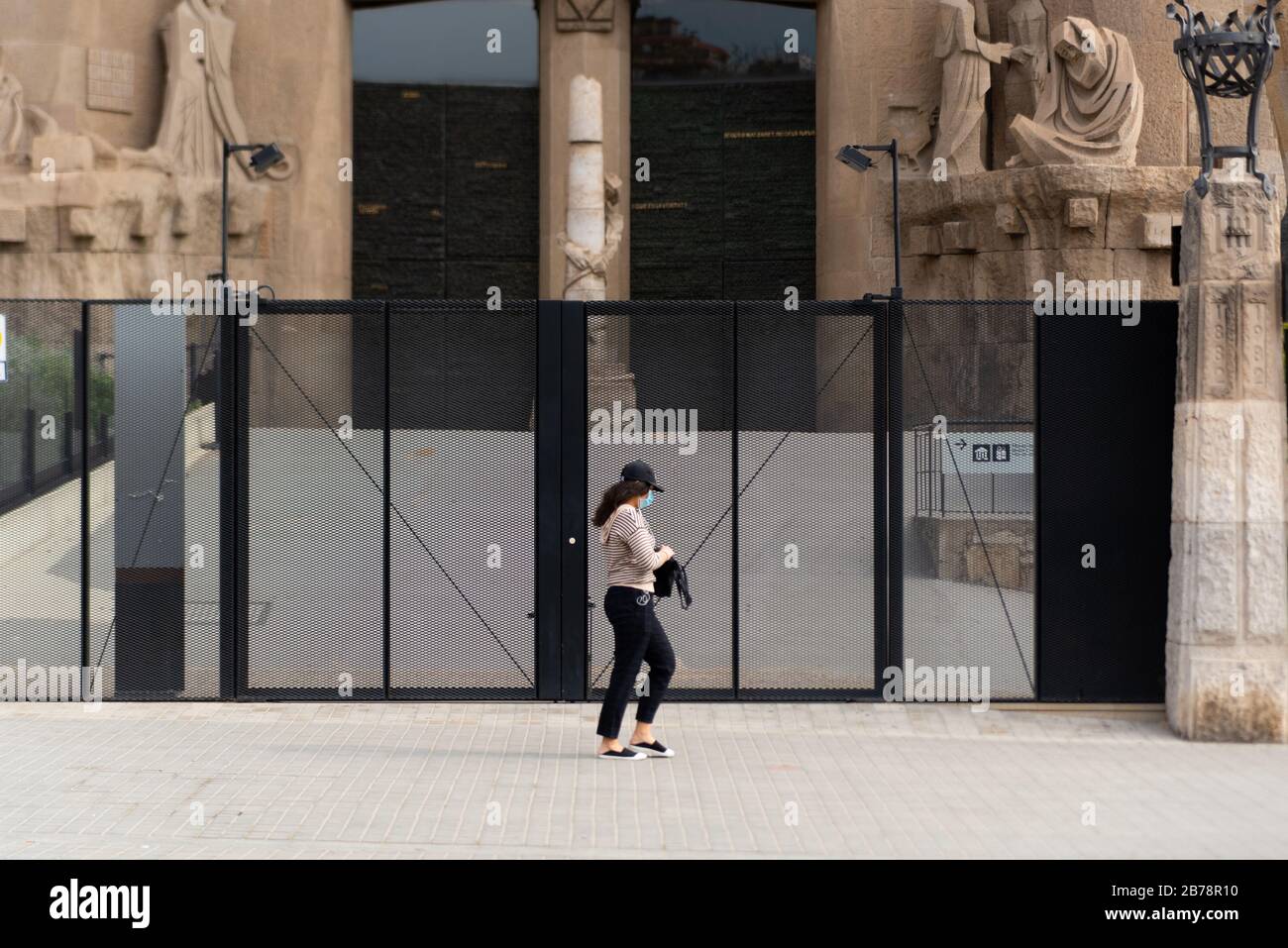 Barcelona, Spain - 14 march 2020: an asian woman walking by the sagrada familia monument wearing protective face mask during the corona virus outbreak Stock Photo