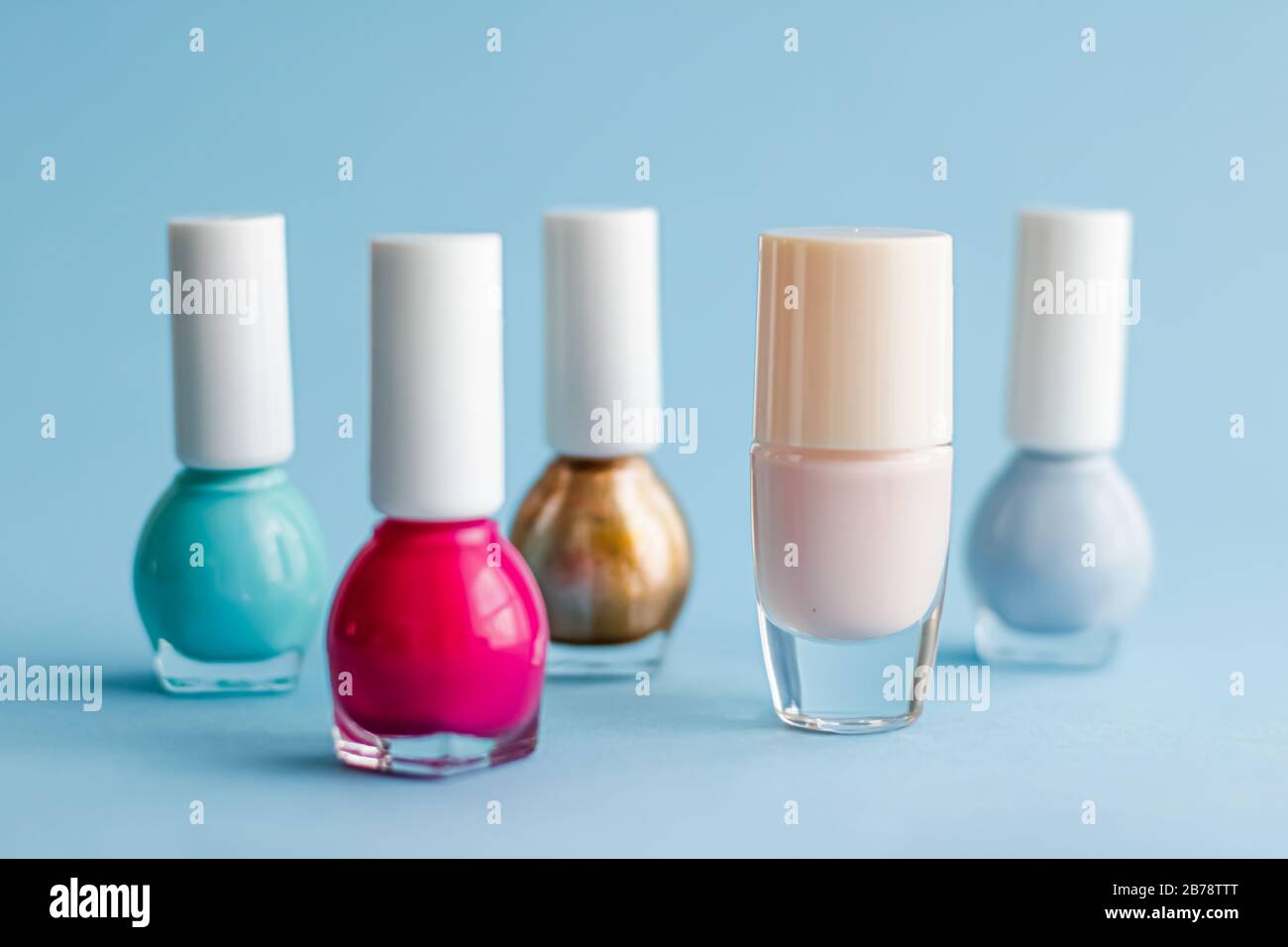 Colourful nail polish bottles on blue background, organic make-up and  cosmetic products for beauty brand, close-up Stock Photo - Alamy