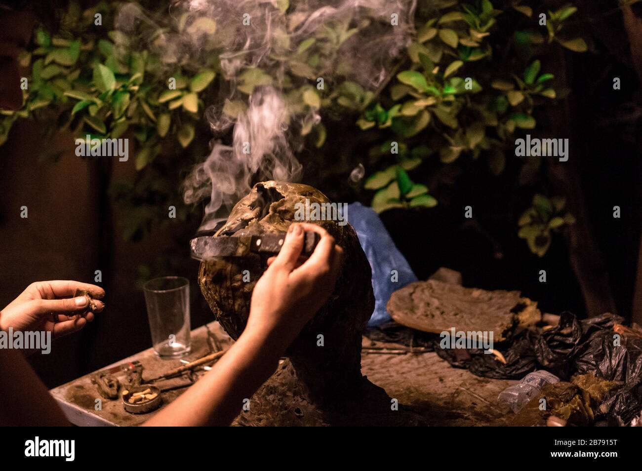 Artist shaping a wax sculpture for bronze molding in a backyard of