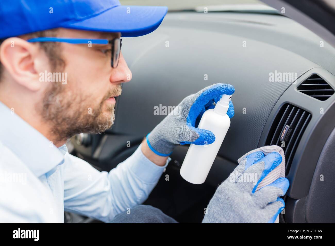 Professional worker using disinfectant and microfiber cloth to clean