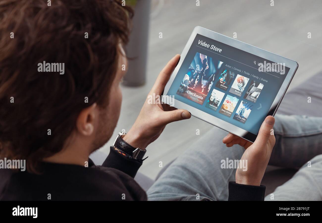 Man using tablet for watching VOD service. Video On Demand television concept Stock Photo