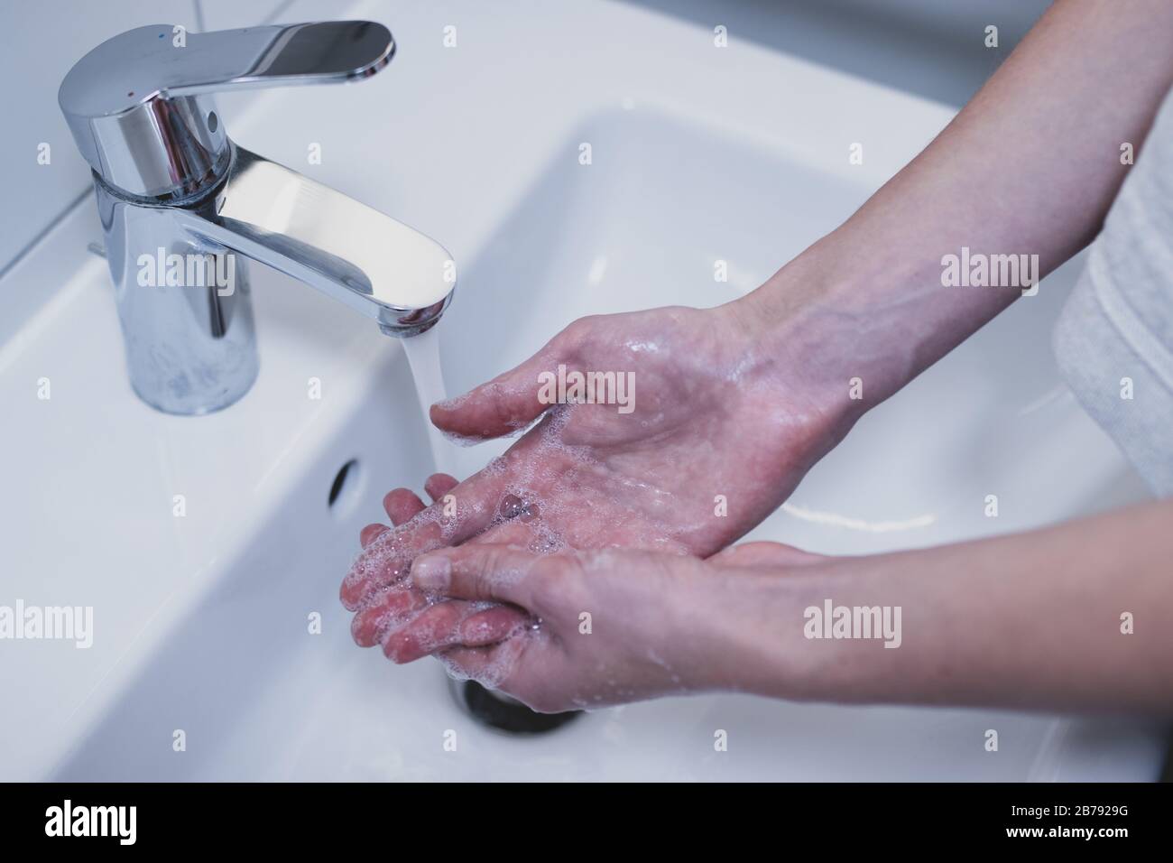 Woman washing her hands with soap in the sink. Royalty free stock photo. Stock Photo