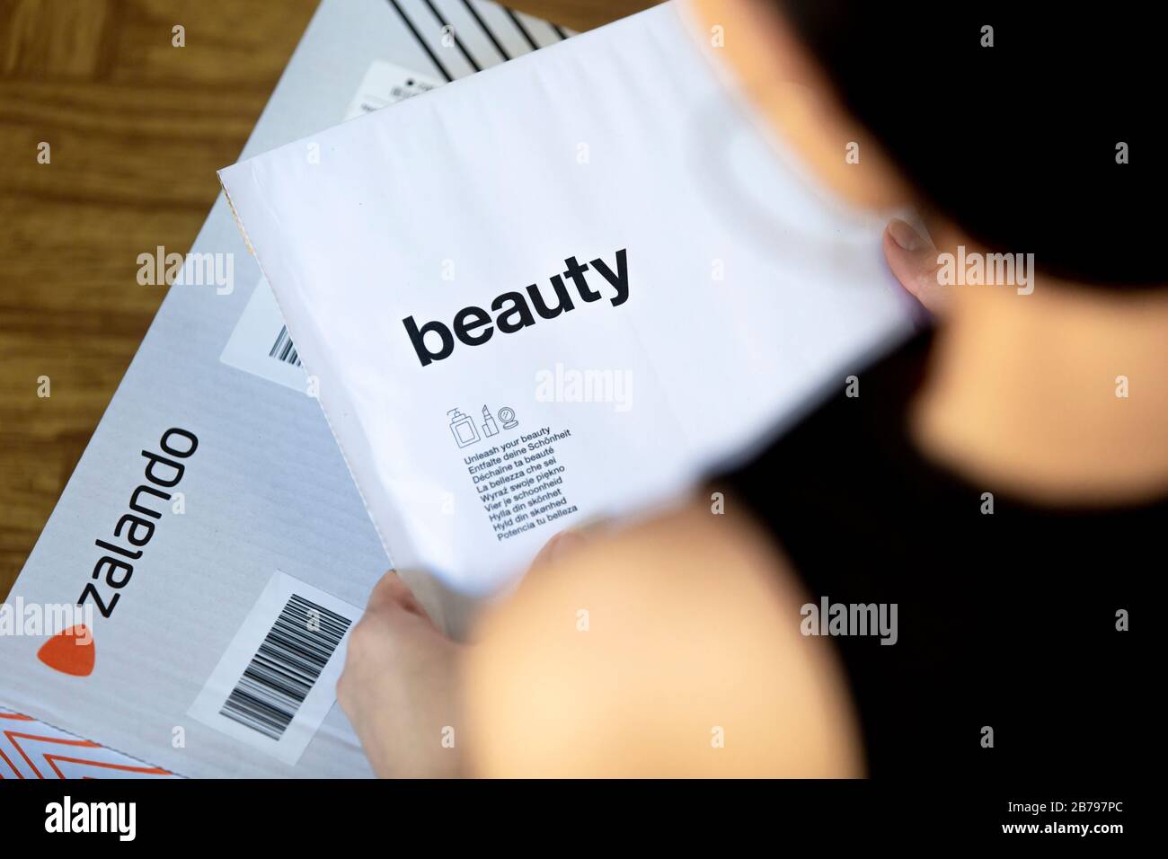 Poznan, Poland - March 14, 2020: Woman holding a Zalando box with ordered items from the online shop. Stock Photo