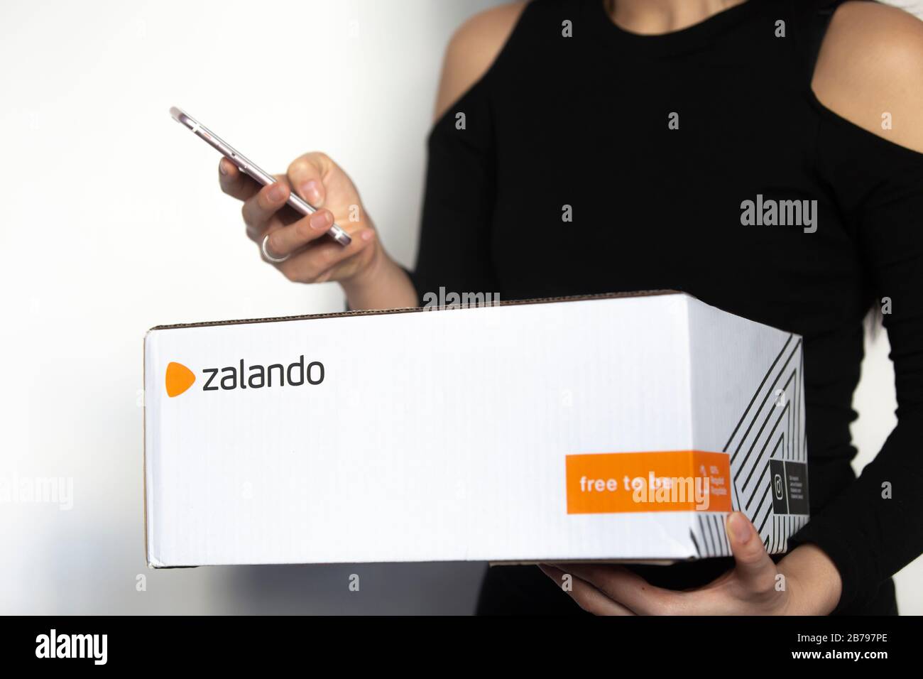 Poznan, Poland - March 14, 2020: Woman holding a Zalando box with ordered items from the online shop. Stock Photo