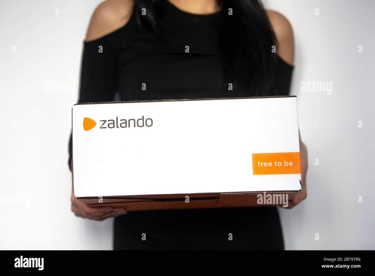 Poznan, Poland - March 14, 2020: Woman holding a Zalando box with ordered items from the online shop. Stock Photo