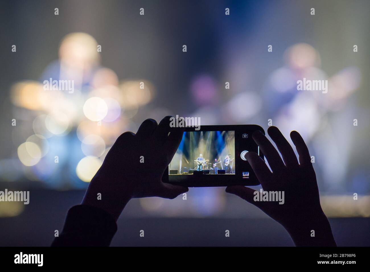 Fan holding smartphone and recording or taking picture during a  concert Stock Photo