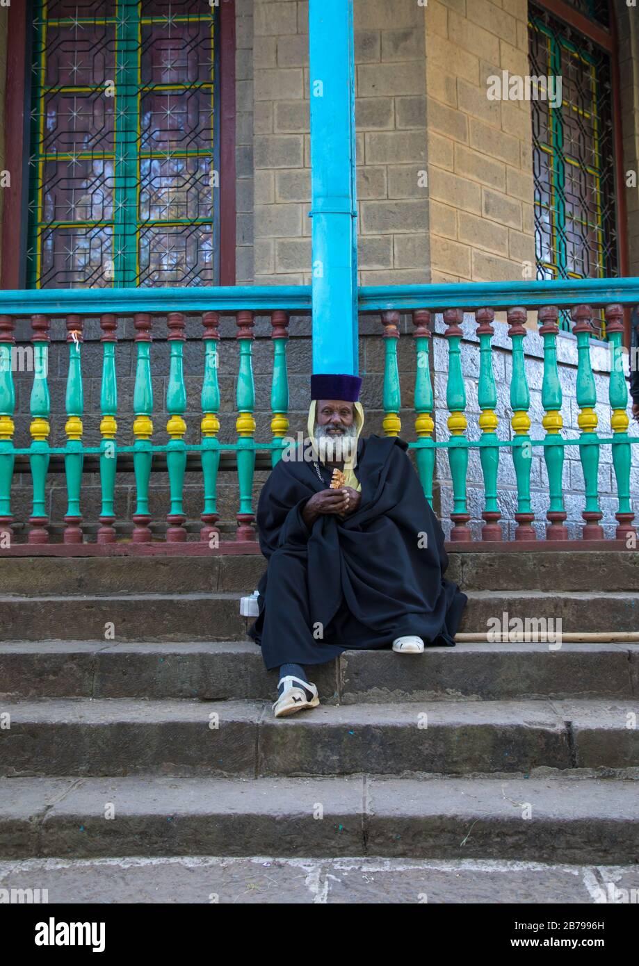 Priest sit on the stairs of the Entoto orthodox Maryam Church, Addis Ababa Region, Addis Ababa, Ethiopia Stock Photo