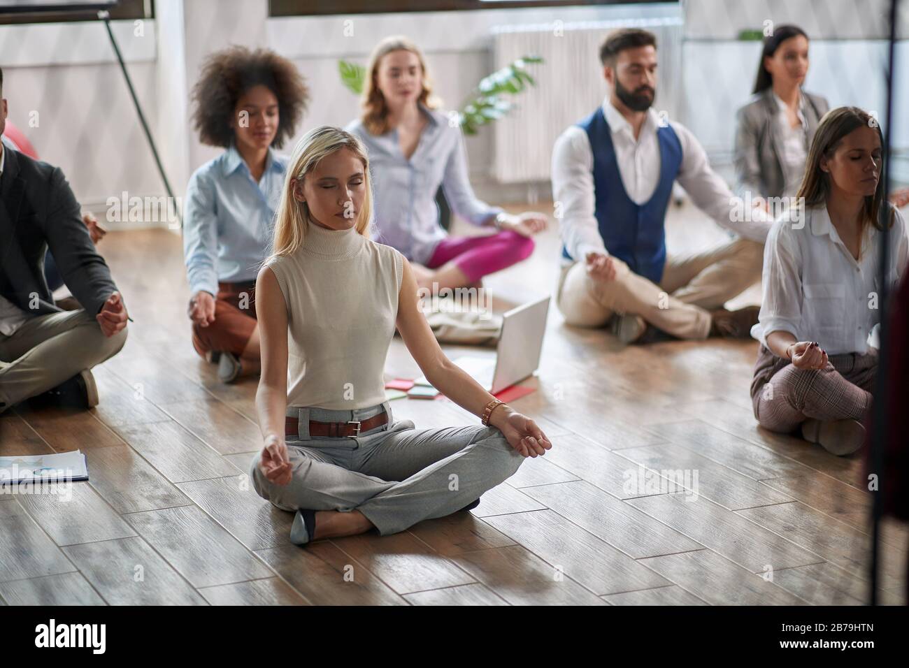 Modern woman meditating at work.coworkers meditating together at work. Stock Photo