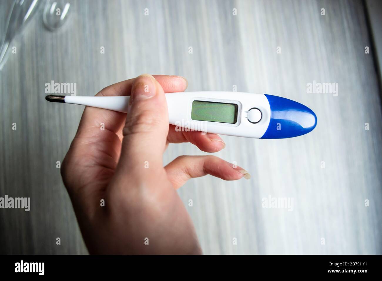 Woman holding a thermometer during the 2020 Coronavirus outbreak Stock Photo