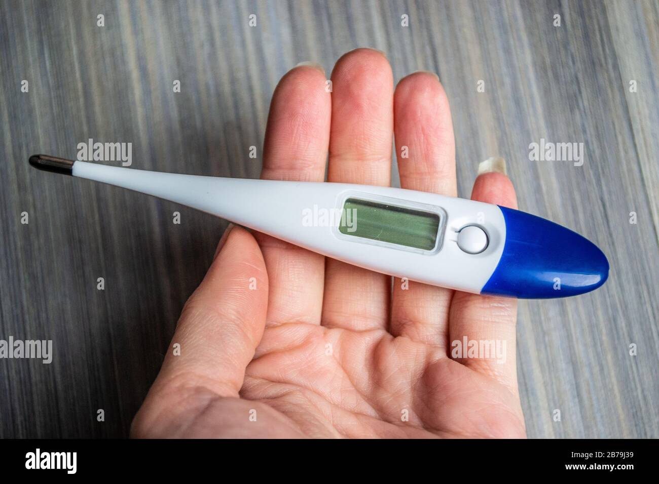 Woman holding a thermometer during the 2020 Coronavirus outbreak Stock Photo