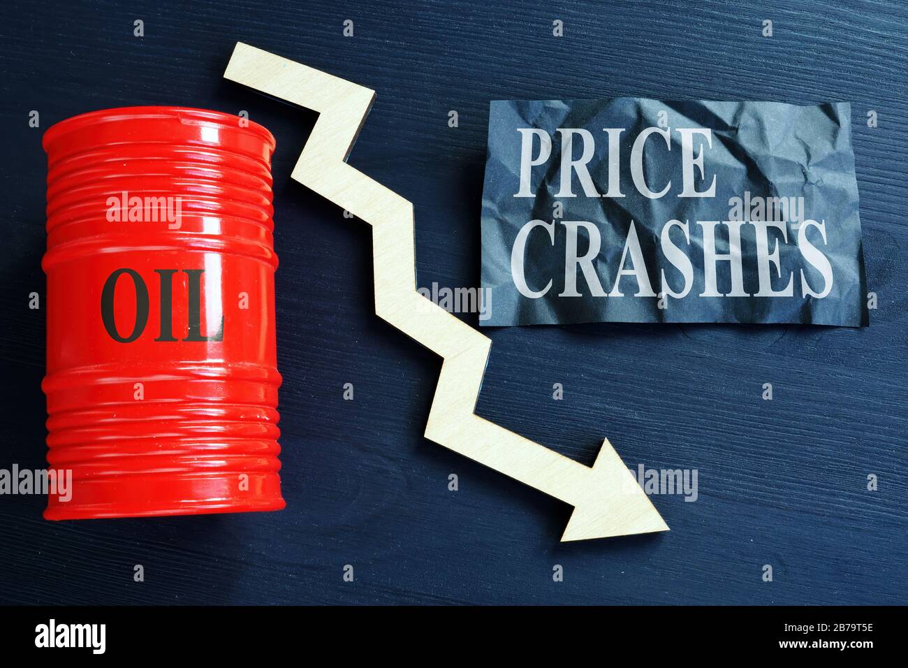 Price crashes sign and crude oil barrel with falling arrow. Stock Photo