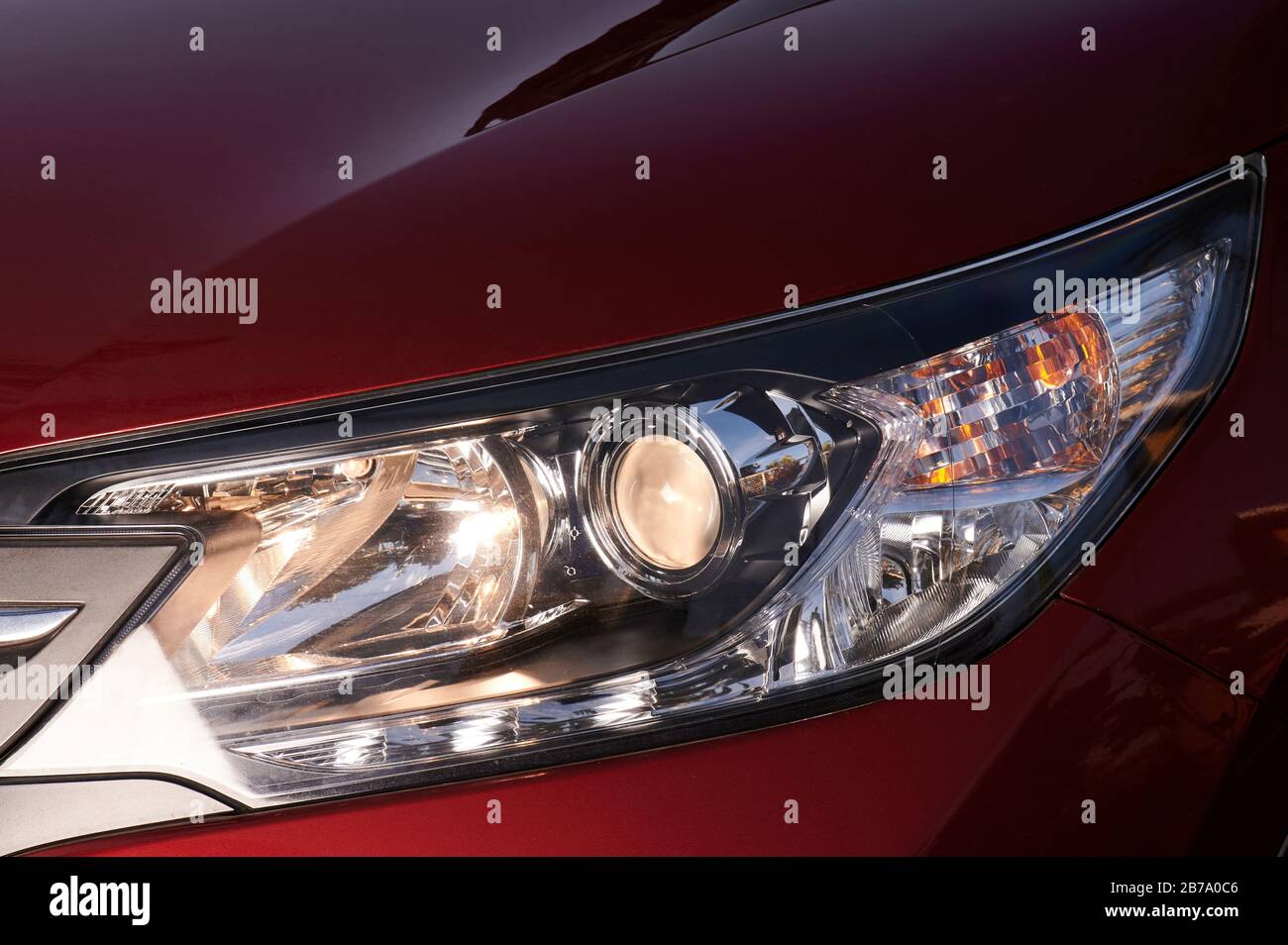 Led headlight of modern red car close up view Stock Photo