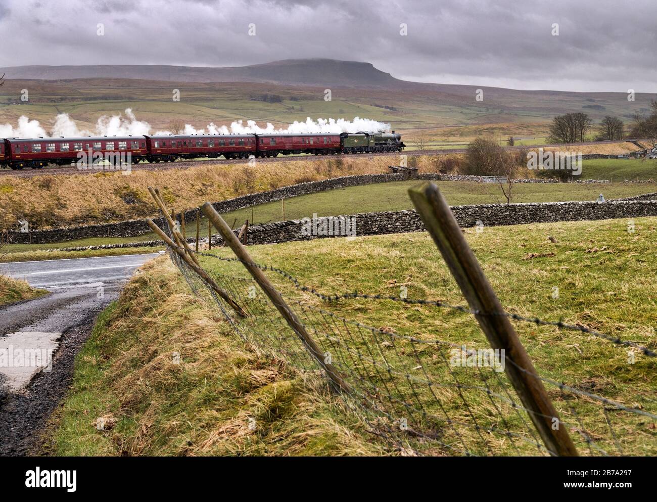 Ribblesdale, North Yorkshire, UK. 14th March, 2020. As the rain falls 'The Winter Cumbrian Mountain Express' steam special hauled by 'Alberta' 45562 (actually sister engine 'Galatea' 45699 in new livery) is seen here at Selside near Horton-in- Ribblesdale, in the Yorkshire Dales National Park, travelling south from Carlisle on the famous Settle to Carlisle railway line.  Pen-y-ghent peak is seen in the background. Credit: John Bentley/Alamy Live News Stock Photo