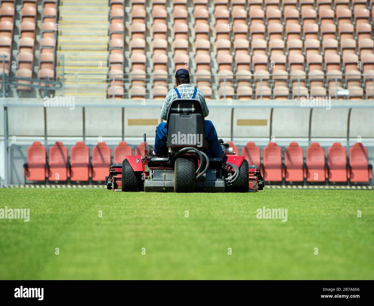 A man mowing the grass on a football stadium. Stock Photo