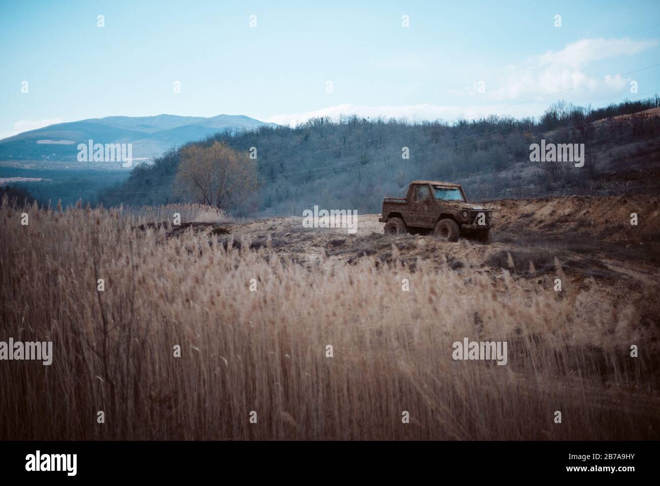 Movie poster, offroad 4x4 jeep car in mud at the top of the hill Stock Photo