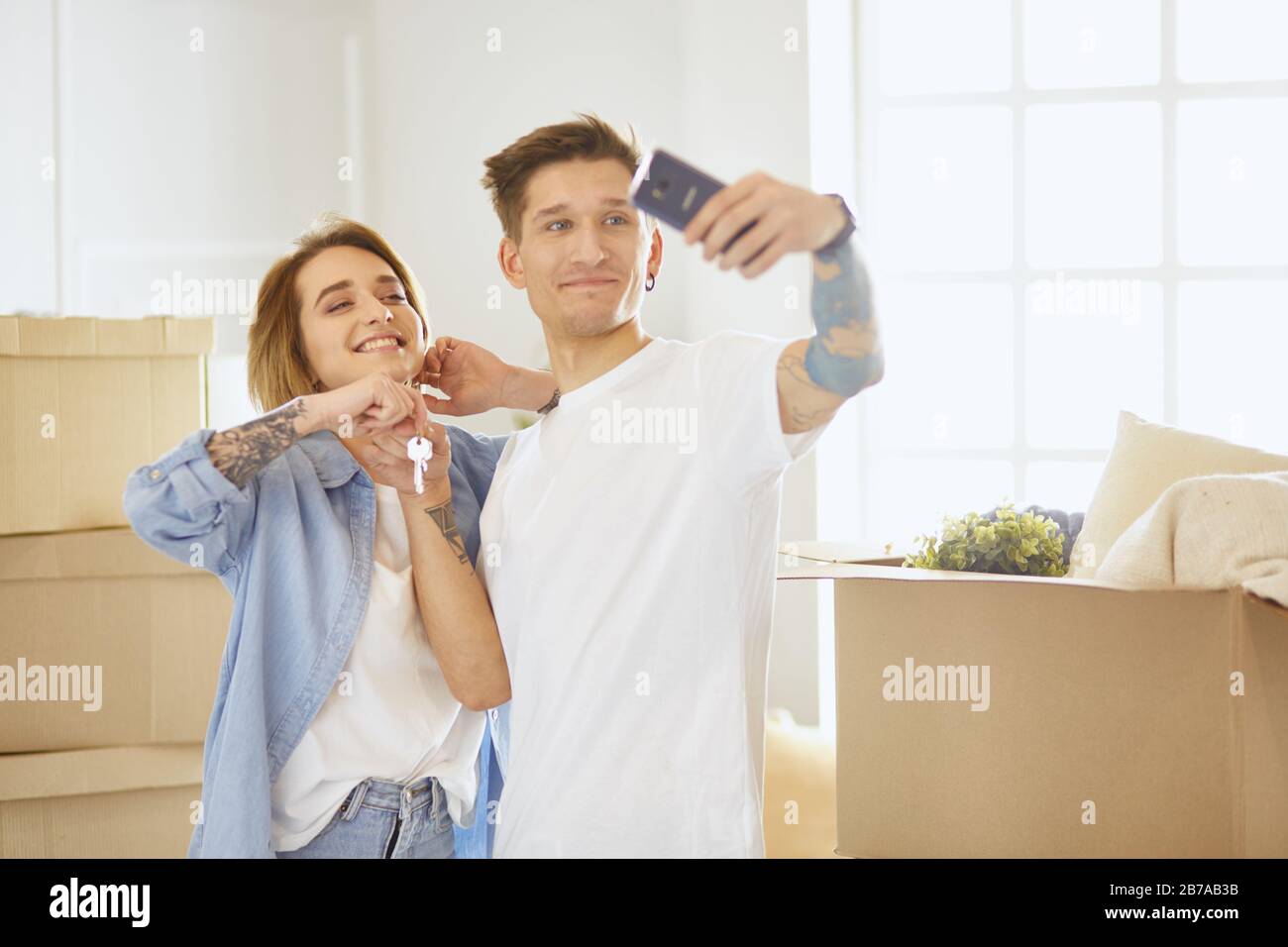 Happy smiling young couple showing a pair of keys of their new house ...
