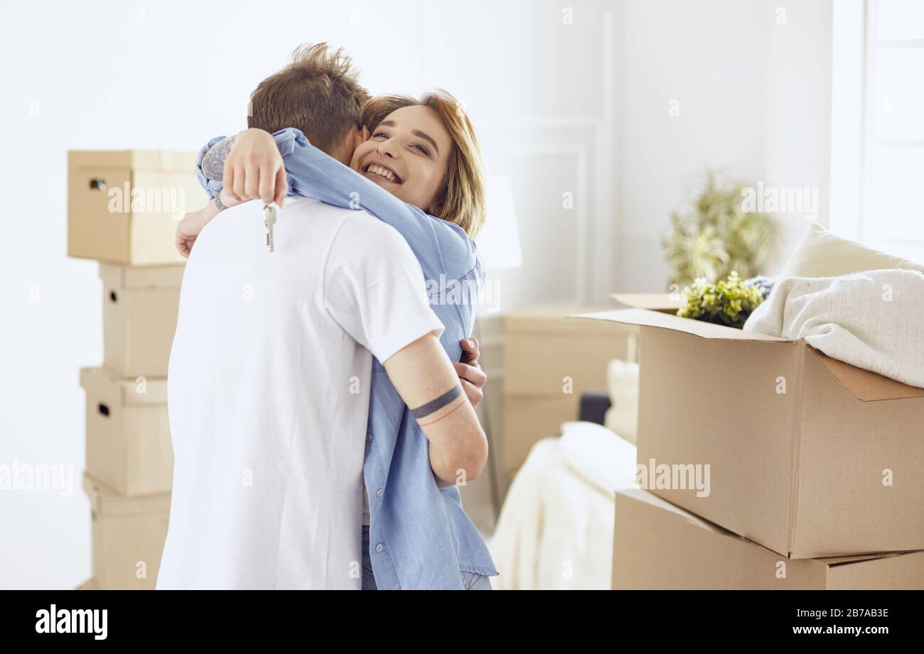 Happy smiling young couple showing a pair of keys of their new house ...