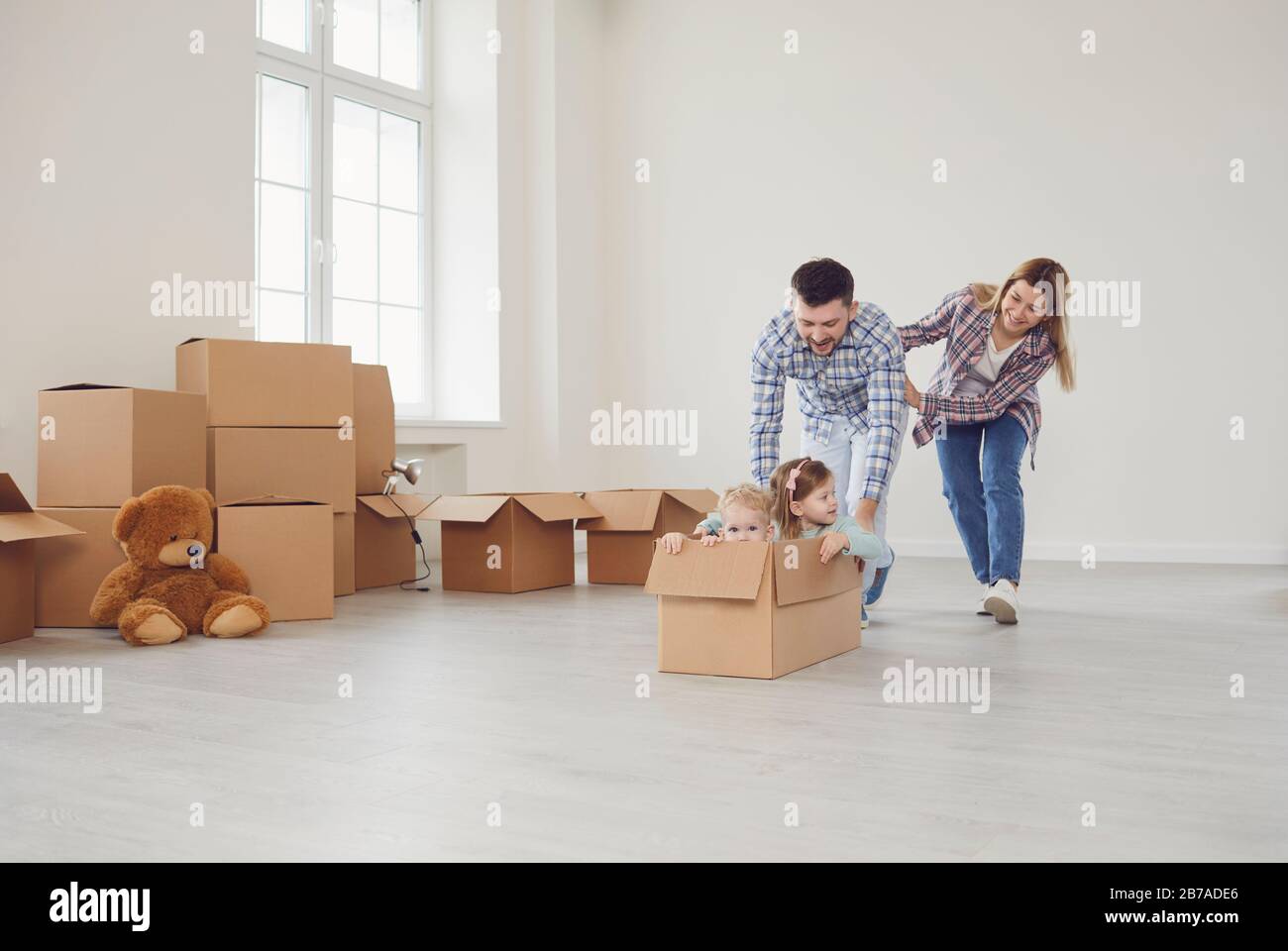 Happy family have fun playing in a new house in the room. Stock Photo