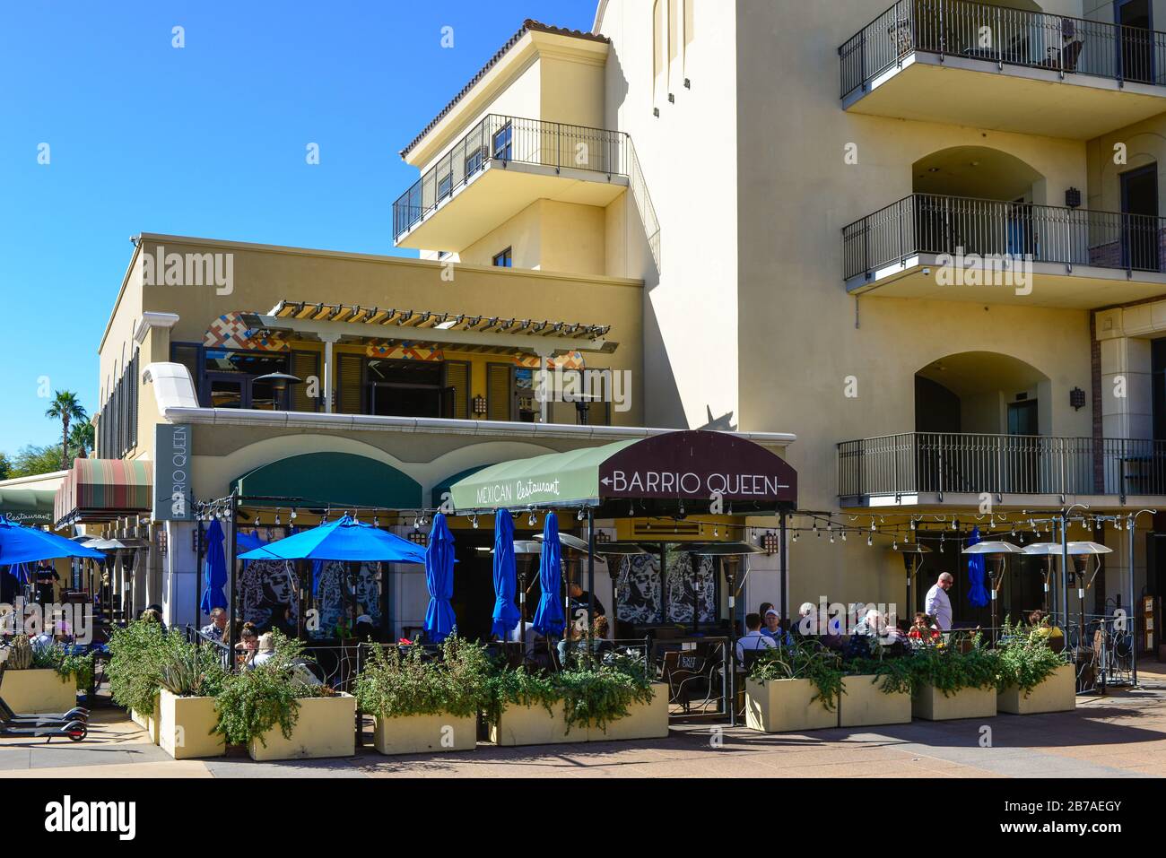 Groups of people drinking and eating at patio style tables outside of the Barrio Queen restaurant, at SouthBridge area in Scottsdale, AZ, USA Stock Photo