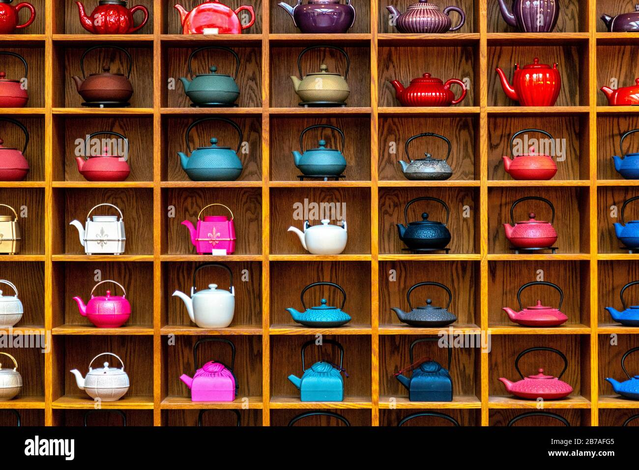 Iron cast teapots (tetsubin) an a wooden shelf at Mariage Frères Tea Emporium and Restaurant, Covent Garden, London, UK Stock Photo