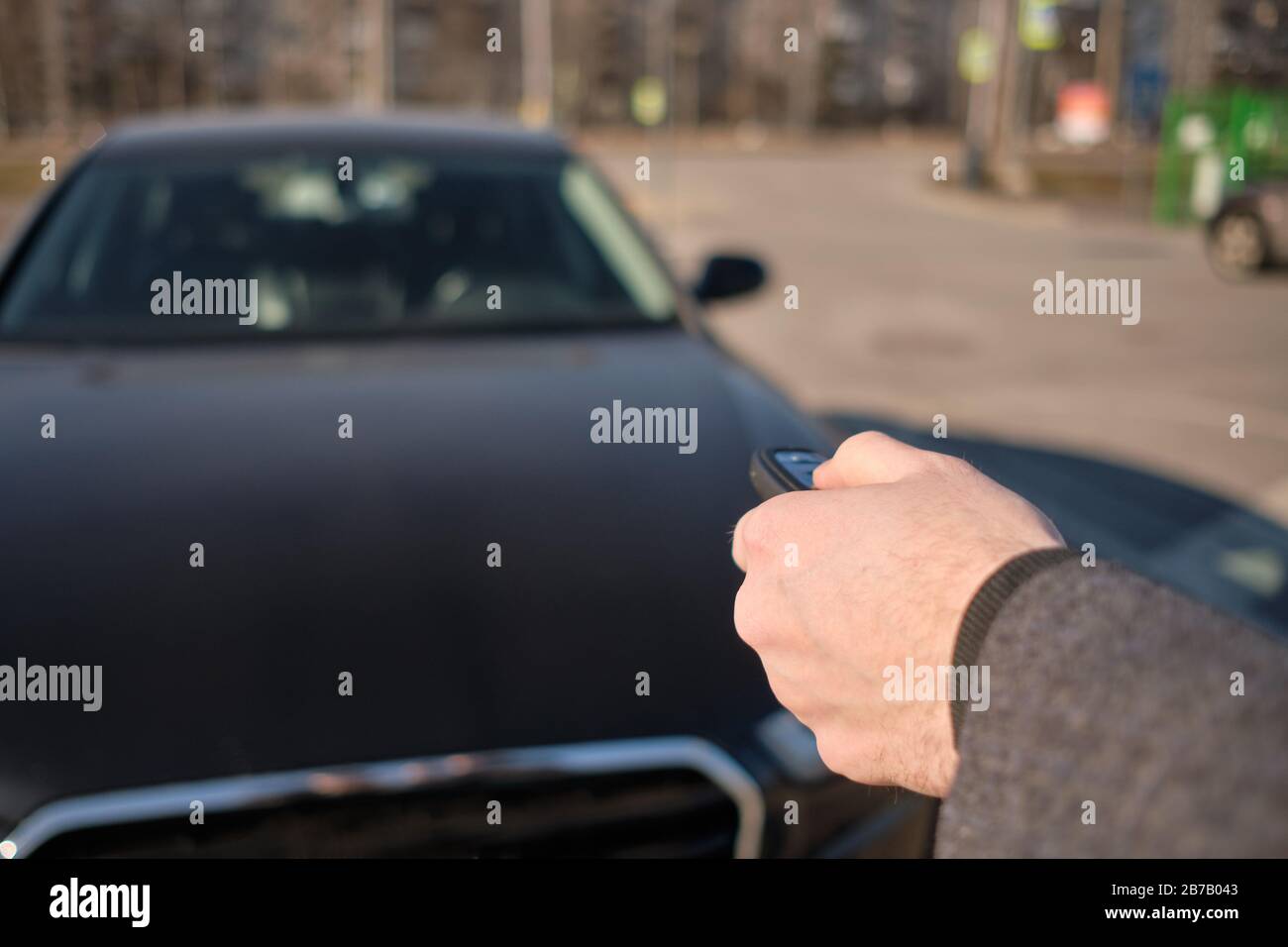 The man in the coat sent the keychain to the car to turn on the alarm. Close up. Stock Photo