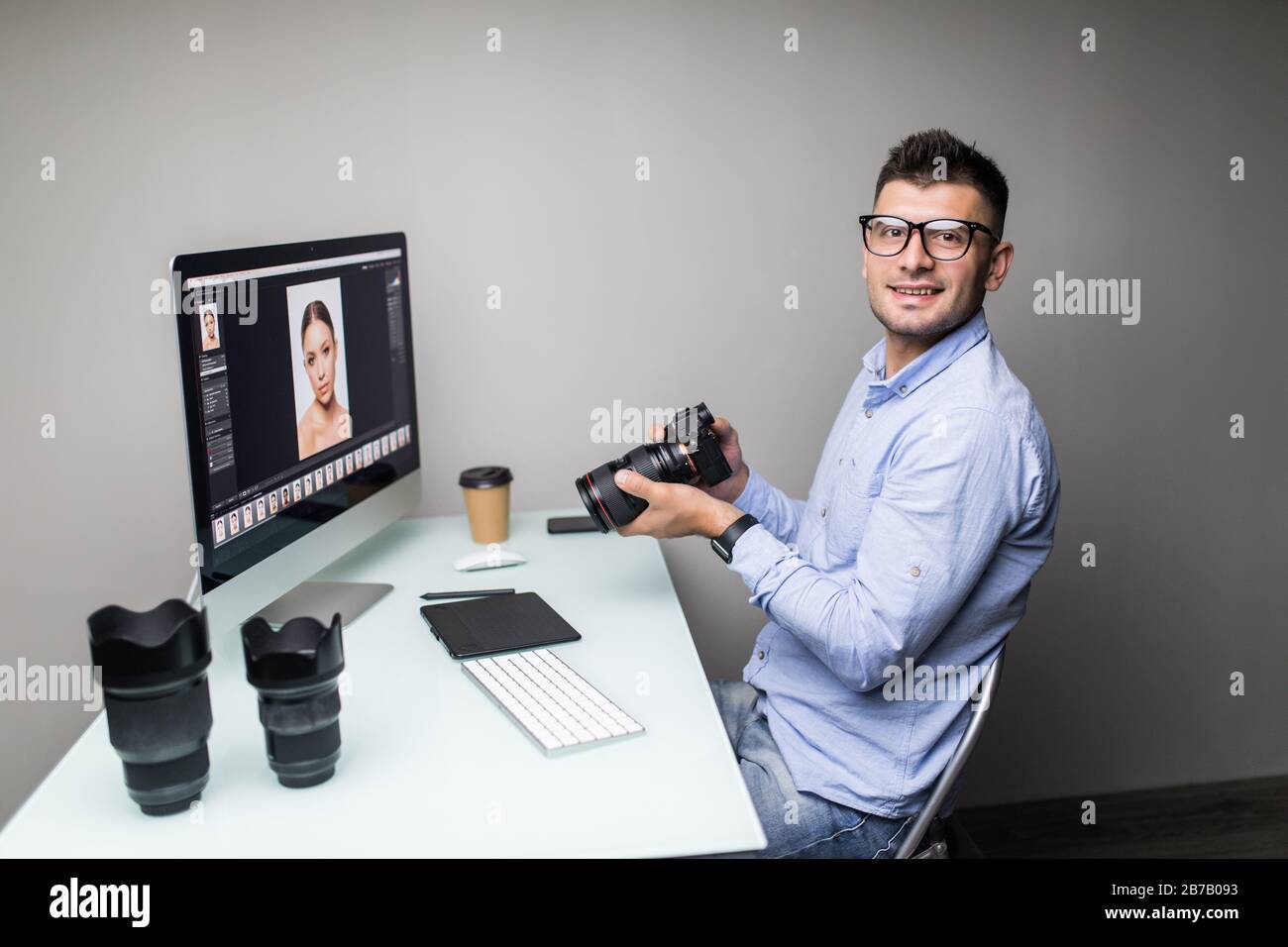 Photographer uploading photos from his camera to the computer Stock