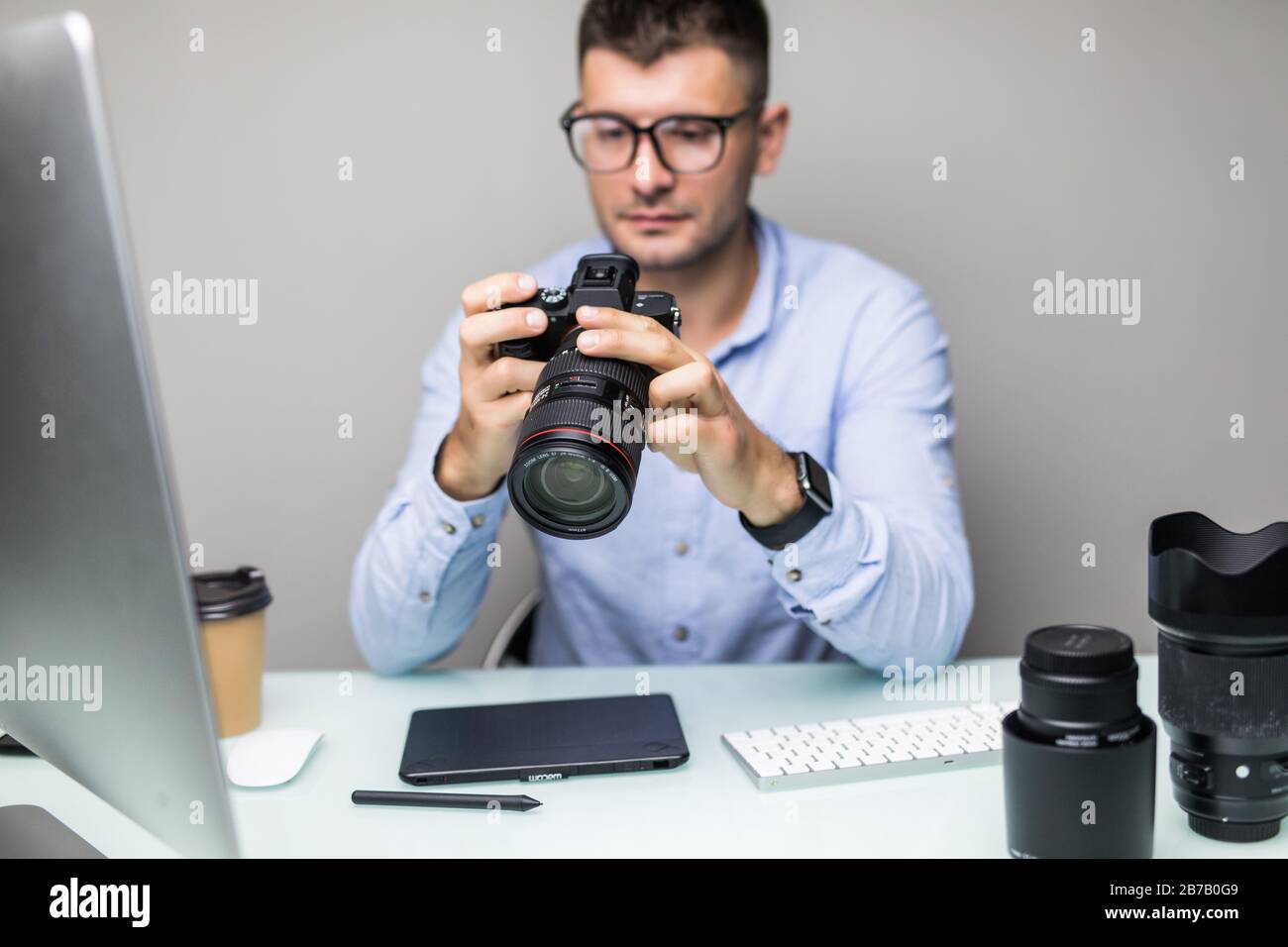 Photographer uploading photos from his camera to the computer Stock