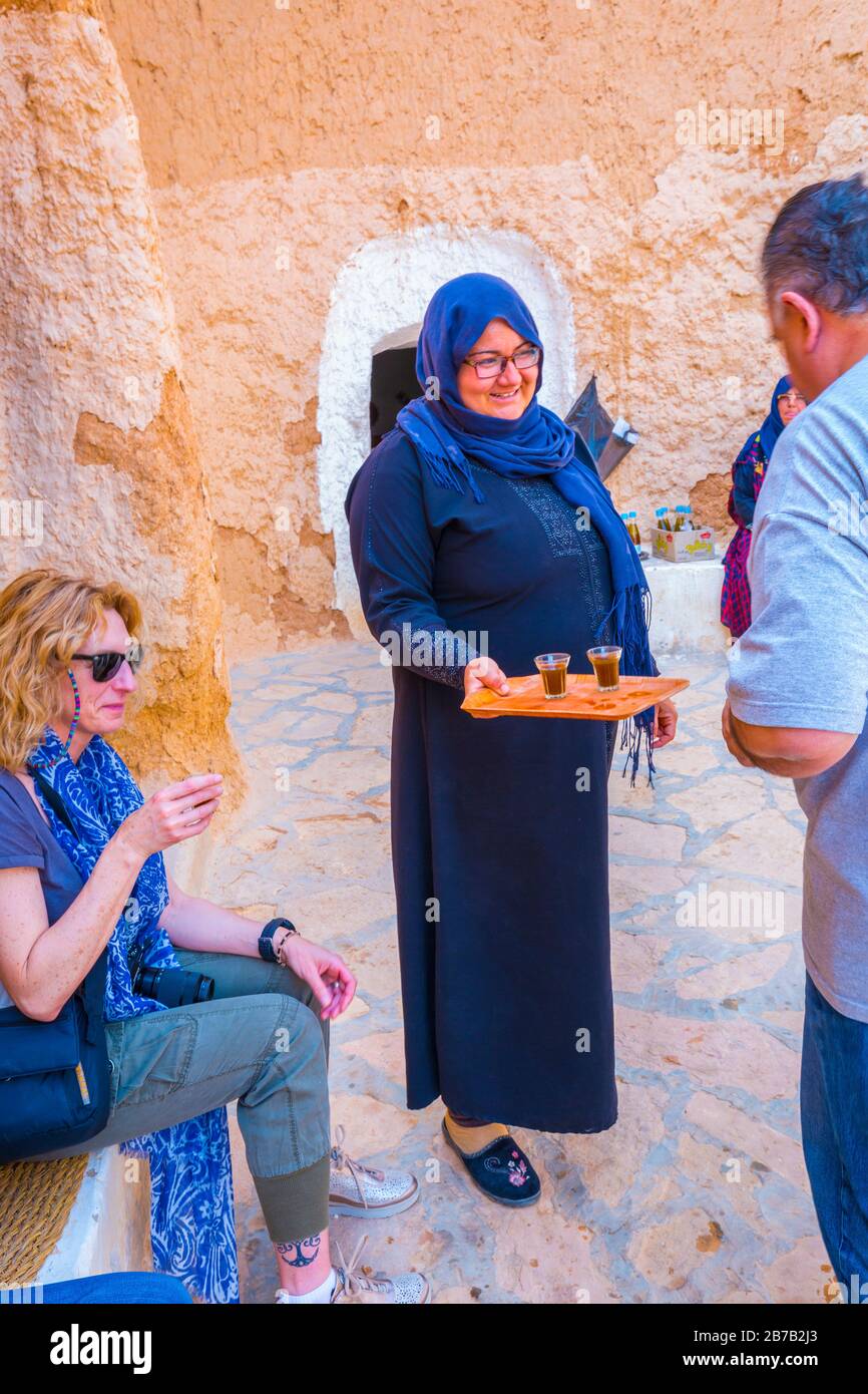 Berber women with tourists in a troglodye house. Matmata. Tunisia, Africa. Stock Photo