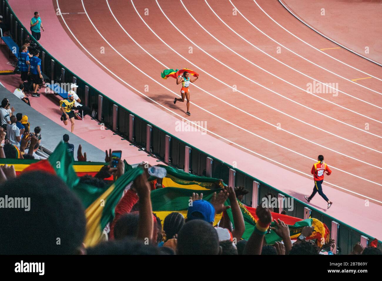 An Ethiopian athlete does a victory jog past supporters at the IAAF