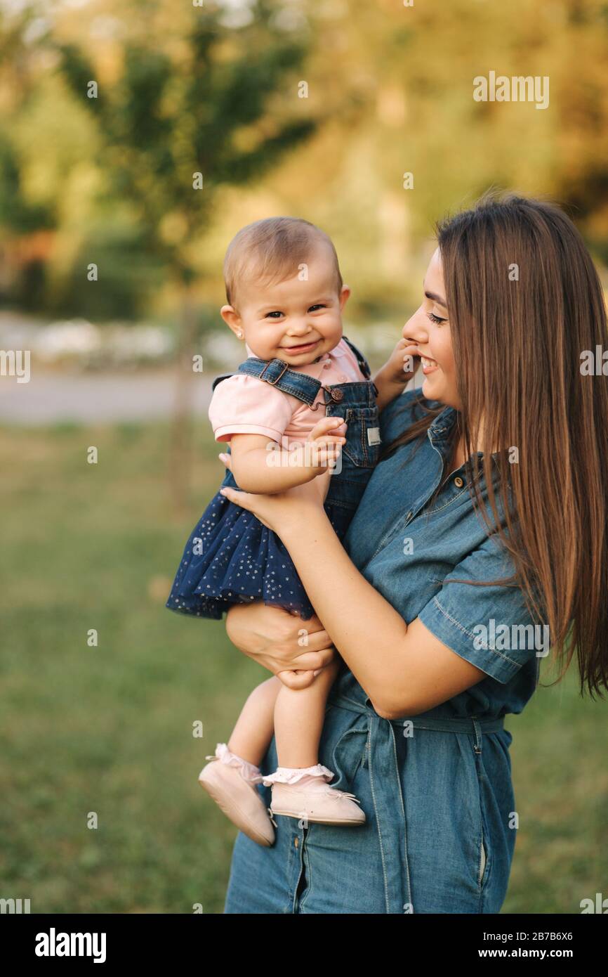 Cute Baby Girl Walking With Her Mom And Have Fun. Stylish Family. Mom And  Daughter In Jeans Stock Photo - Alamy