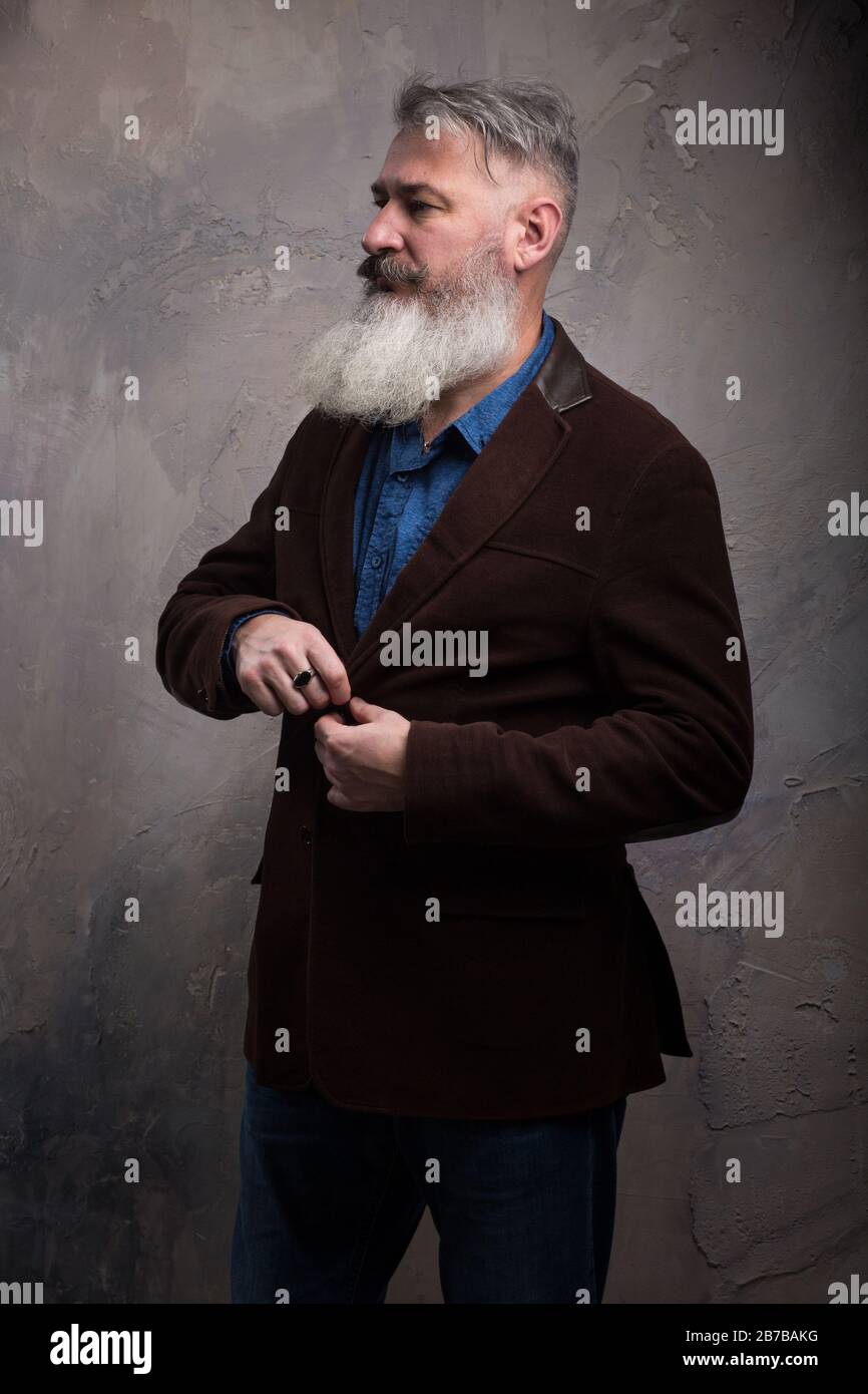 Portrait of a Middle Age Man with Beard and Mustache Posing in Informal Wear on a Dark Backdrop, selective focus Stock Photo