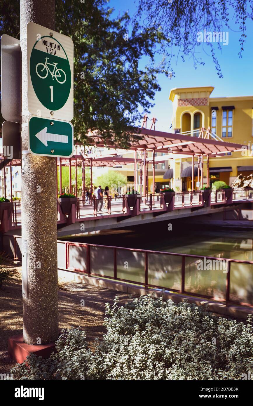 A green and white sign points an arrow towards the Mountain Vista Bike route on the Scottsdale waterfront at the upmarket condos of the AZ Canal area Stock Photo