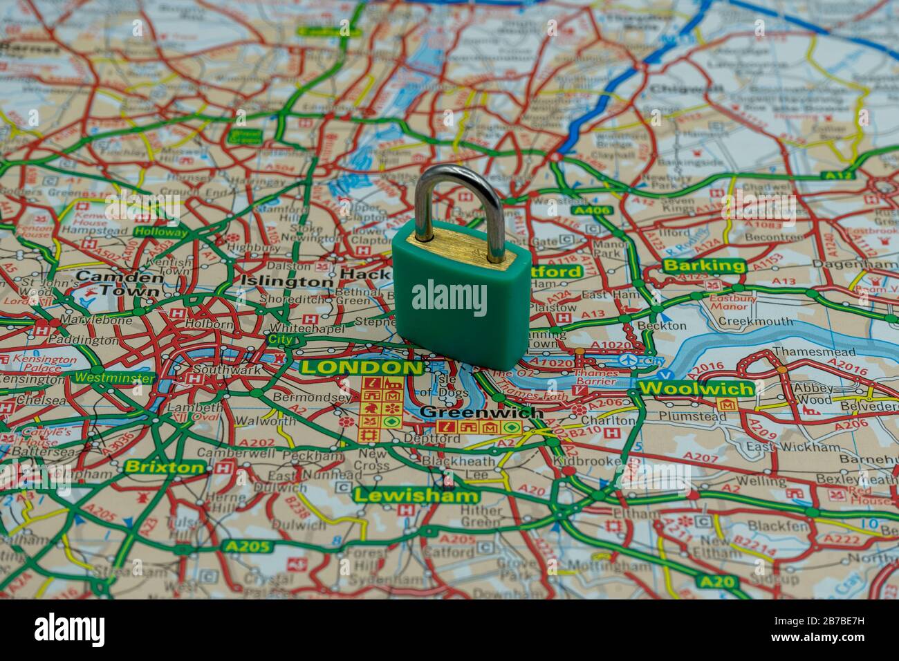 A locked padlock on top of a road map or geography map of London UK Stock Photo