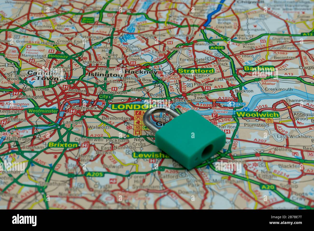 A locked padlock on top of a road map or geography map of London UK Stock Photo