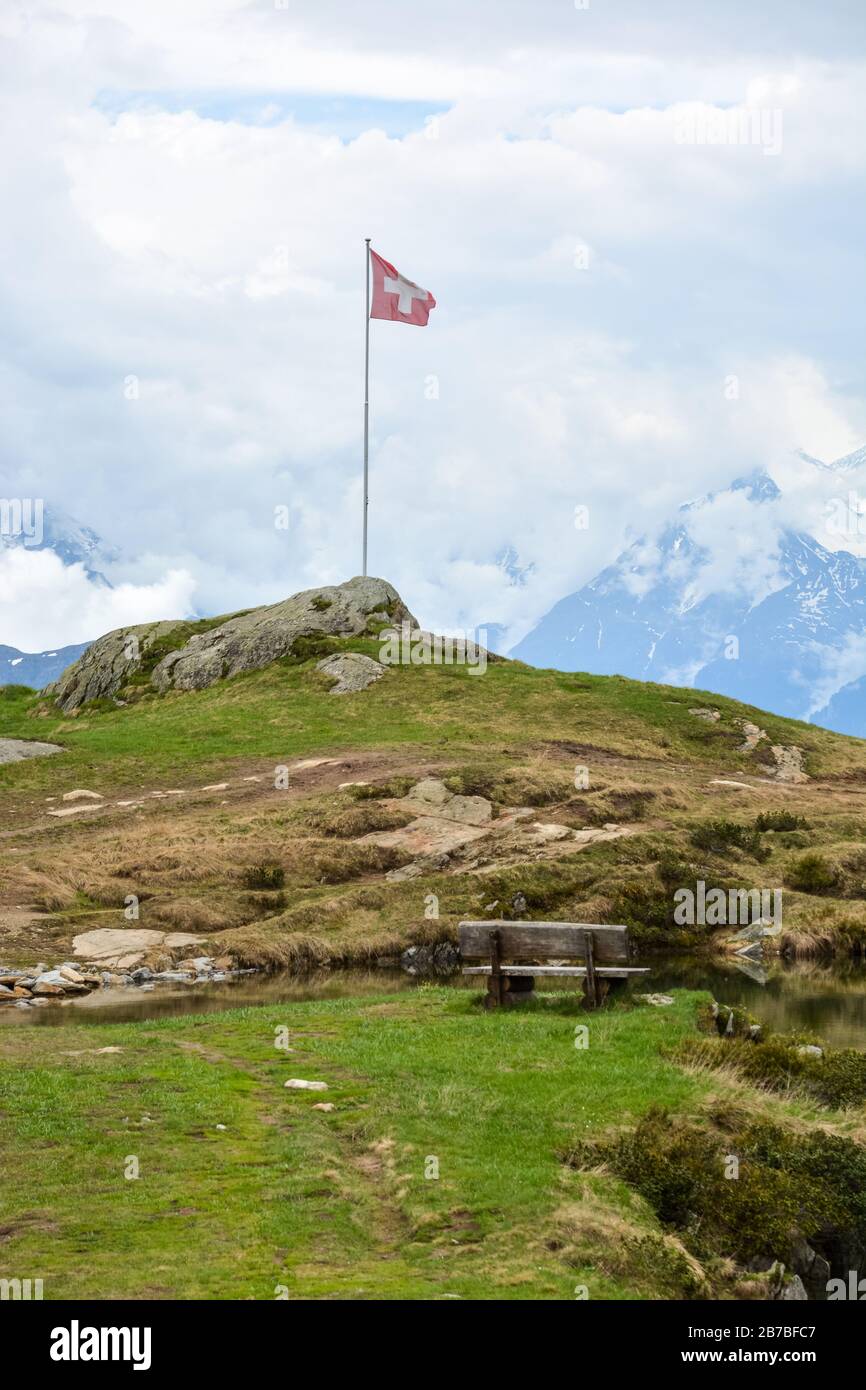 A Swiss flag in the swiss mountains near Bettmeralp and Aletsch glacier Stock Photo