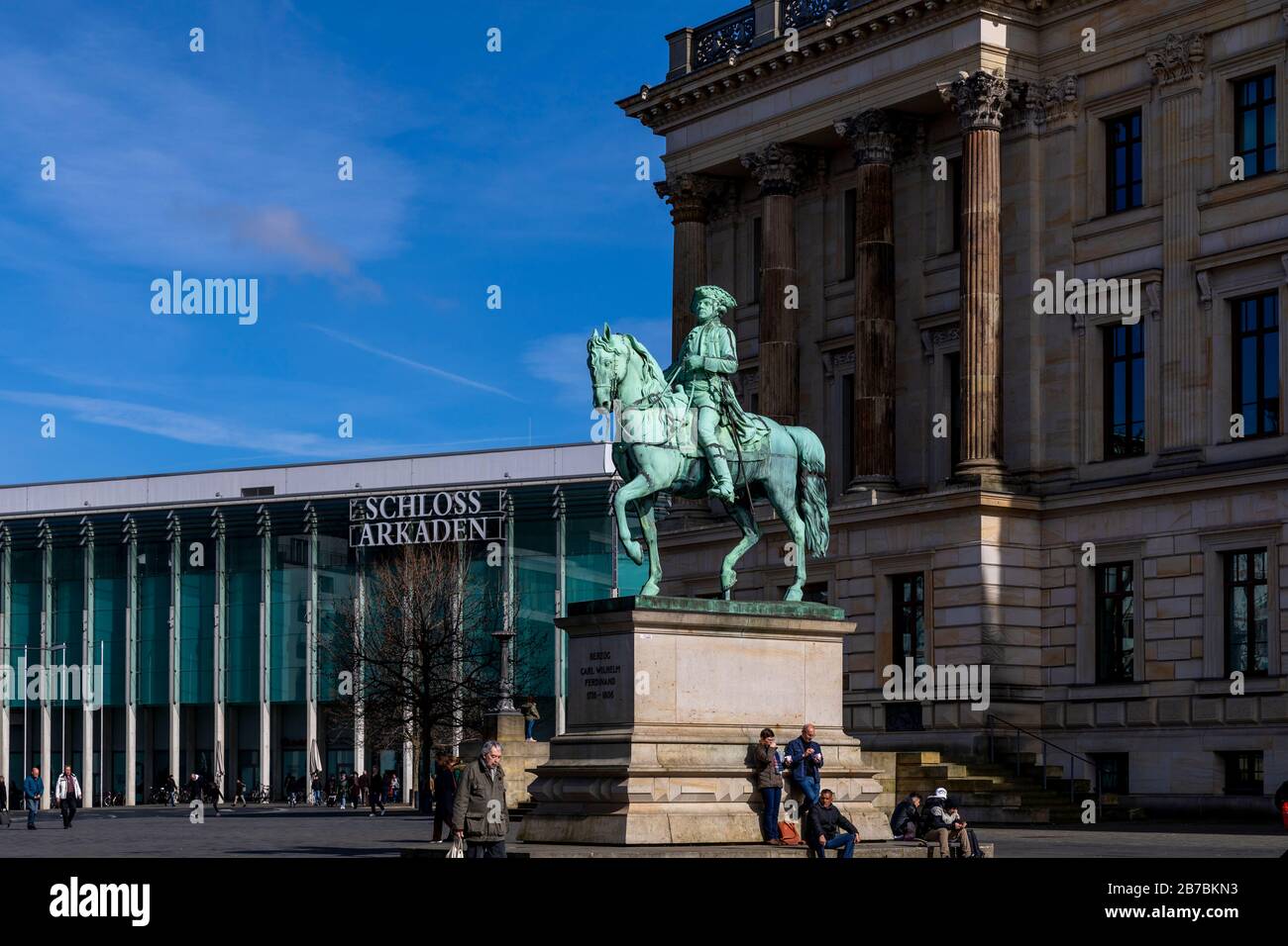People enjoying sunny spring day in Braunschweig. Schloss-Arkaden shopping mall provides with surrounding and fear of corona virus is not visible. Stock Photo