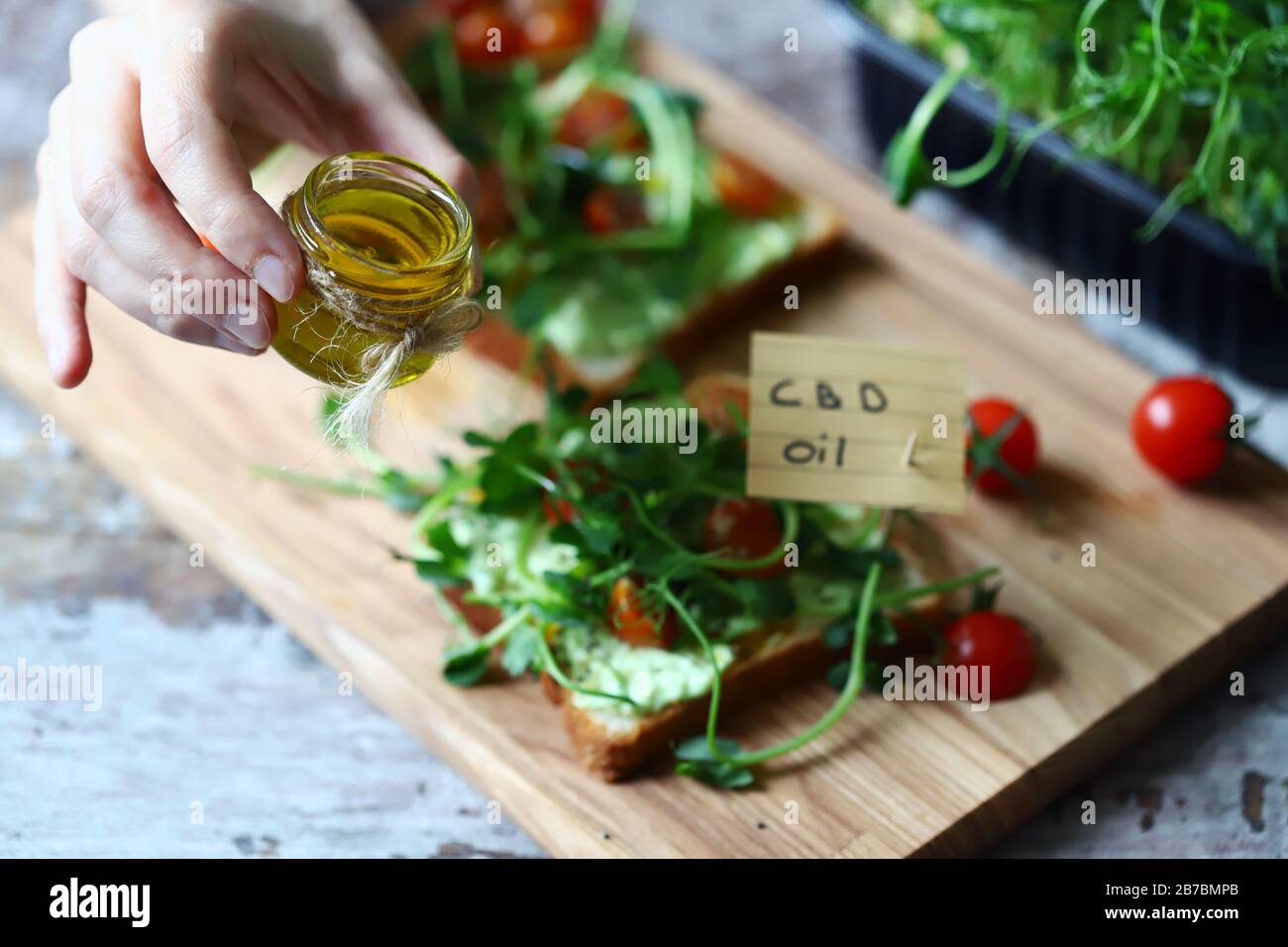 Selective focus. Healthy toasts with microgreens and cbd oil. Cannabidiol concept. CBD oil. Cbd food. Stock Photo