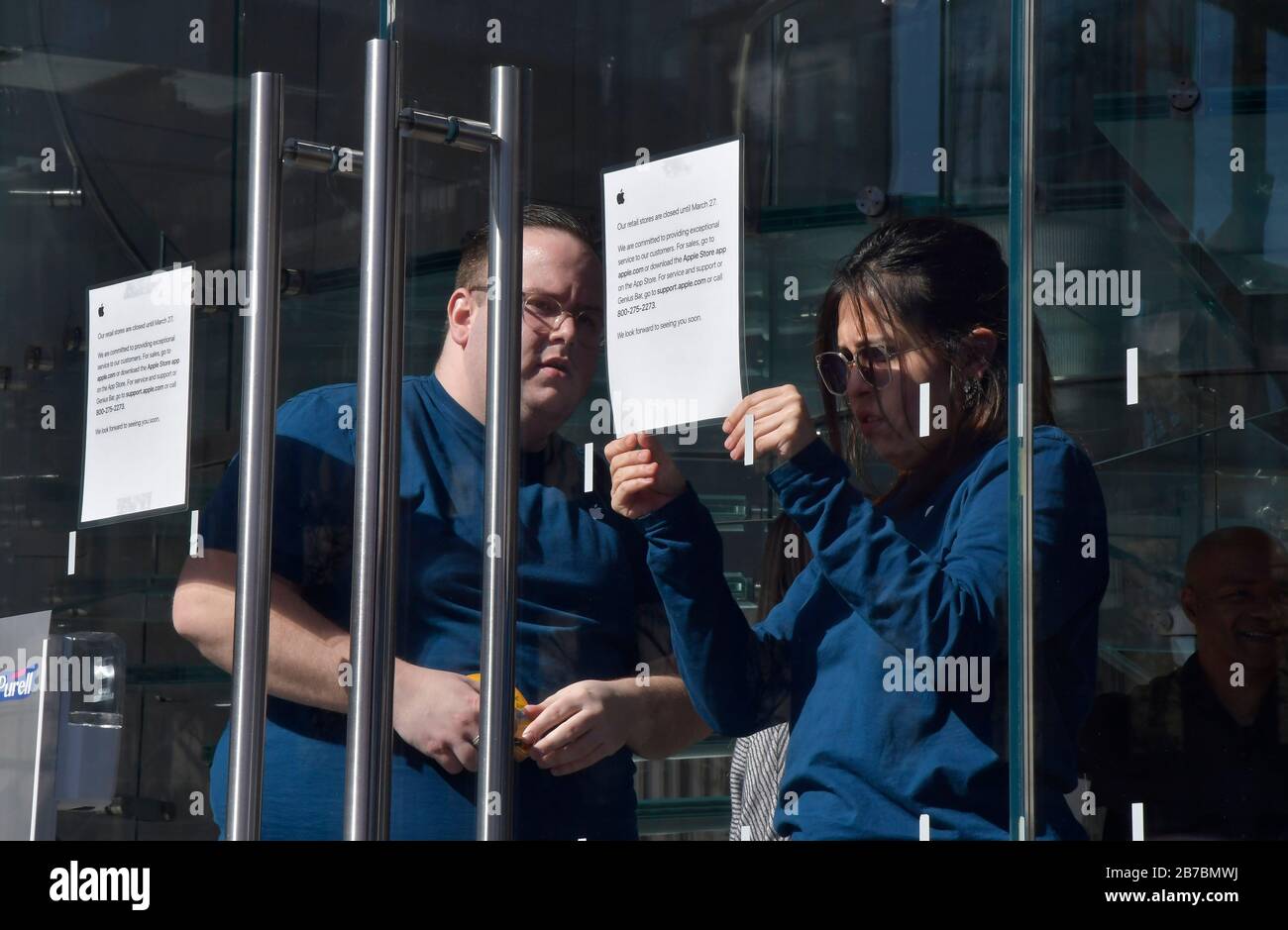 New York, USA. 14th Mar, 2020. Apple employees at the Manhattan Apple store in the Meatpacking District tape signs indicating the closure of its store on Saturday, March 14, 2020 in New York. Apple CEO Tim Cook announced it will close all its retail stores outside Greater China until March 27th in order to o minimize the risk of transmission of COVID-19 virus. (Photo by Louis Lanzano/Sipa USA) Credit: Sipa USA/Alamy Live News Stock Photo