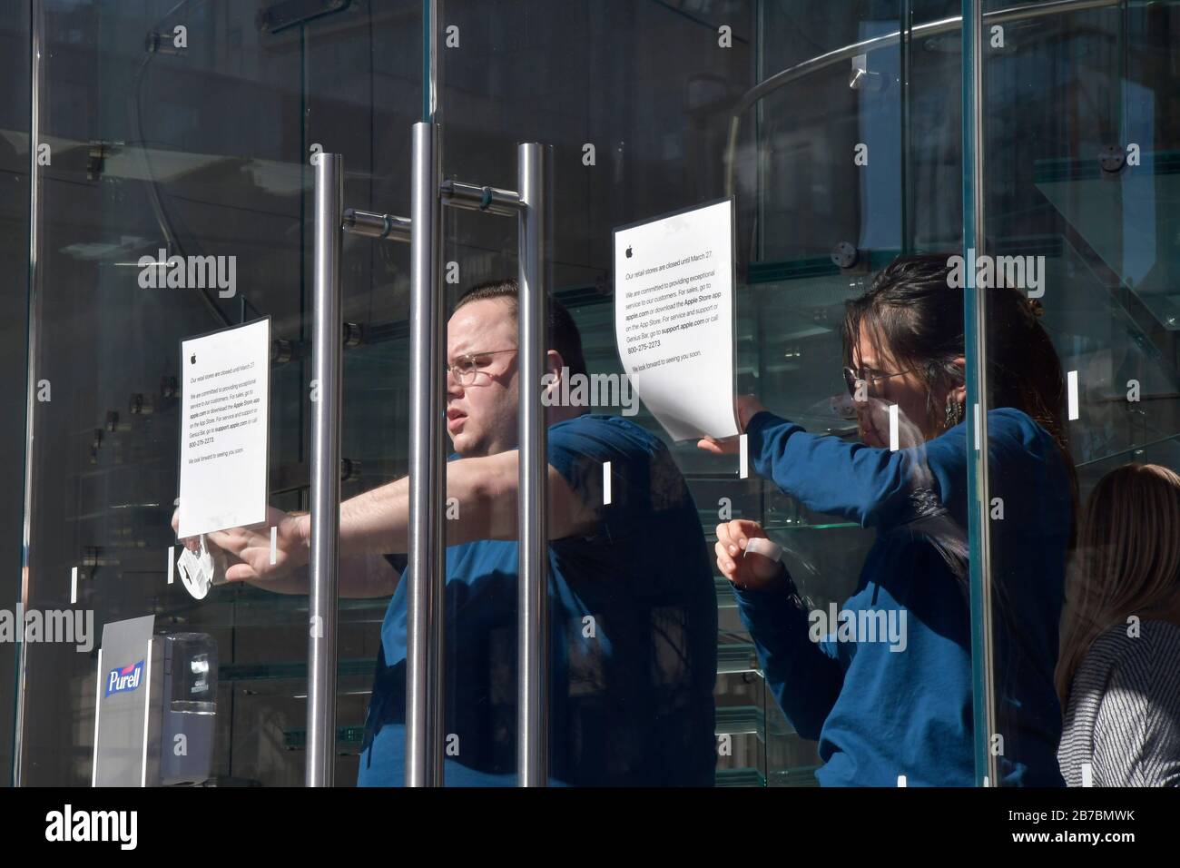 New York, USA. 14th Mar, 2020. Apple employees at the Manhattan Apple store in the Meatpacking District tape signs indicating the closure of its store on Saturday, March 14, 2020 in New York. Apple CEO Tim Cook announced it will close all its retail stores outside Greater China until March 27th in order to o minimize the risk of transmission of COVID-19 virus. (Photo by Louis Lanzano/Sipa USA) Credit: Sipa USA/Alamy Live News Stock Photo