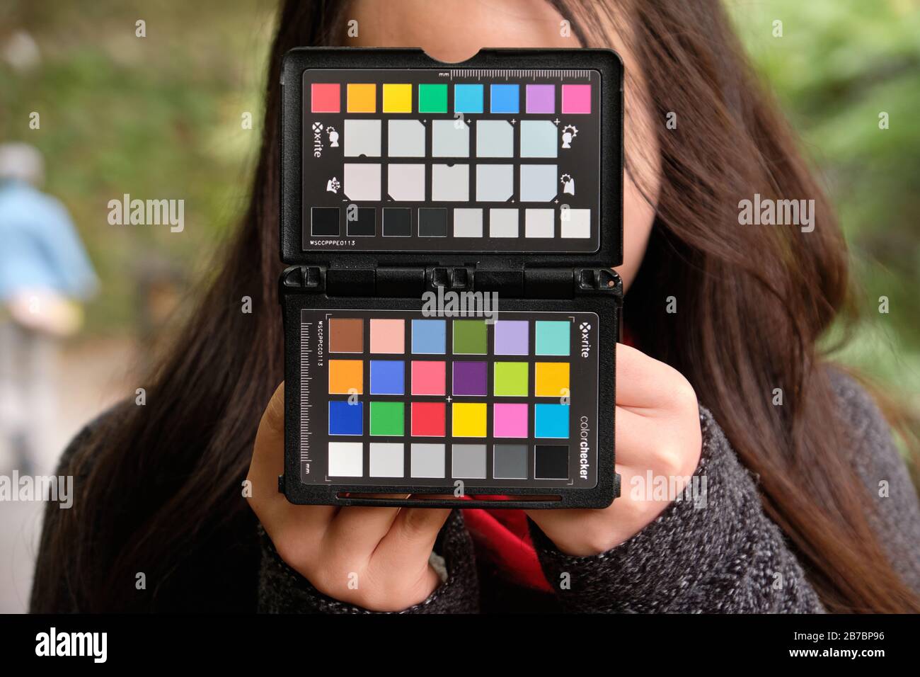 Woman holding X-rite colorchecker passport on location for camera white balance and color calibration photo Stock Photo